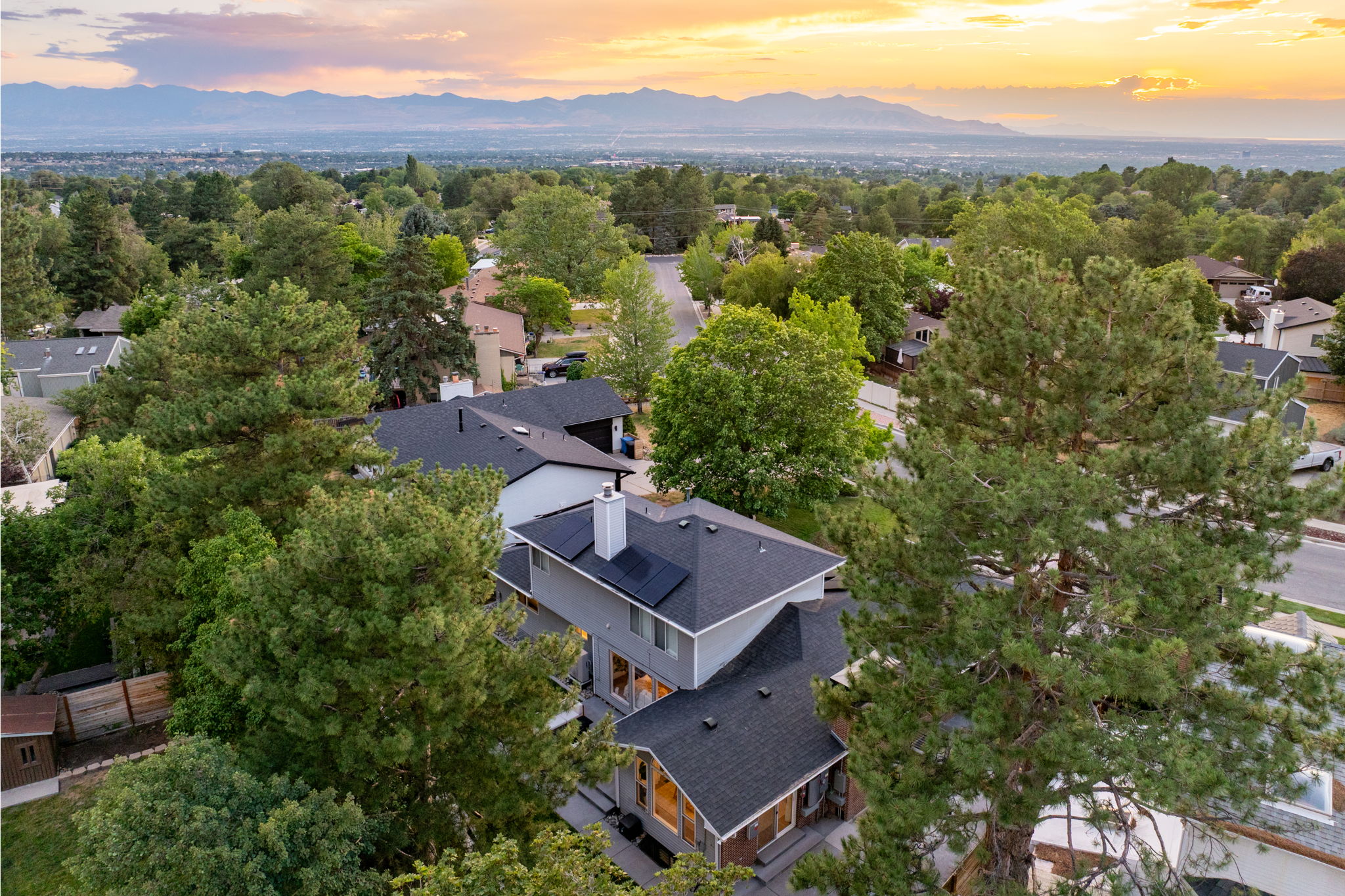 Contemporary multi-level residence with a dark shingle roof and solar panels
