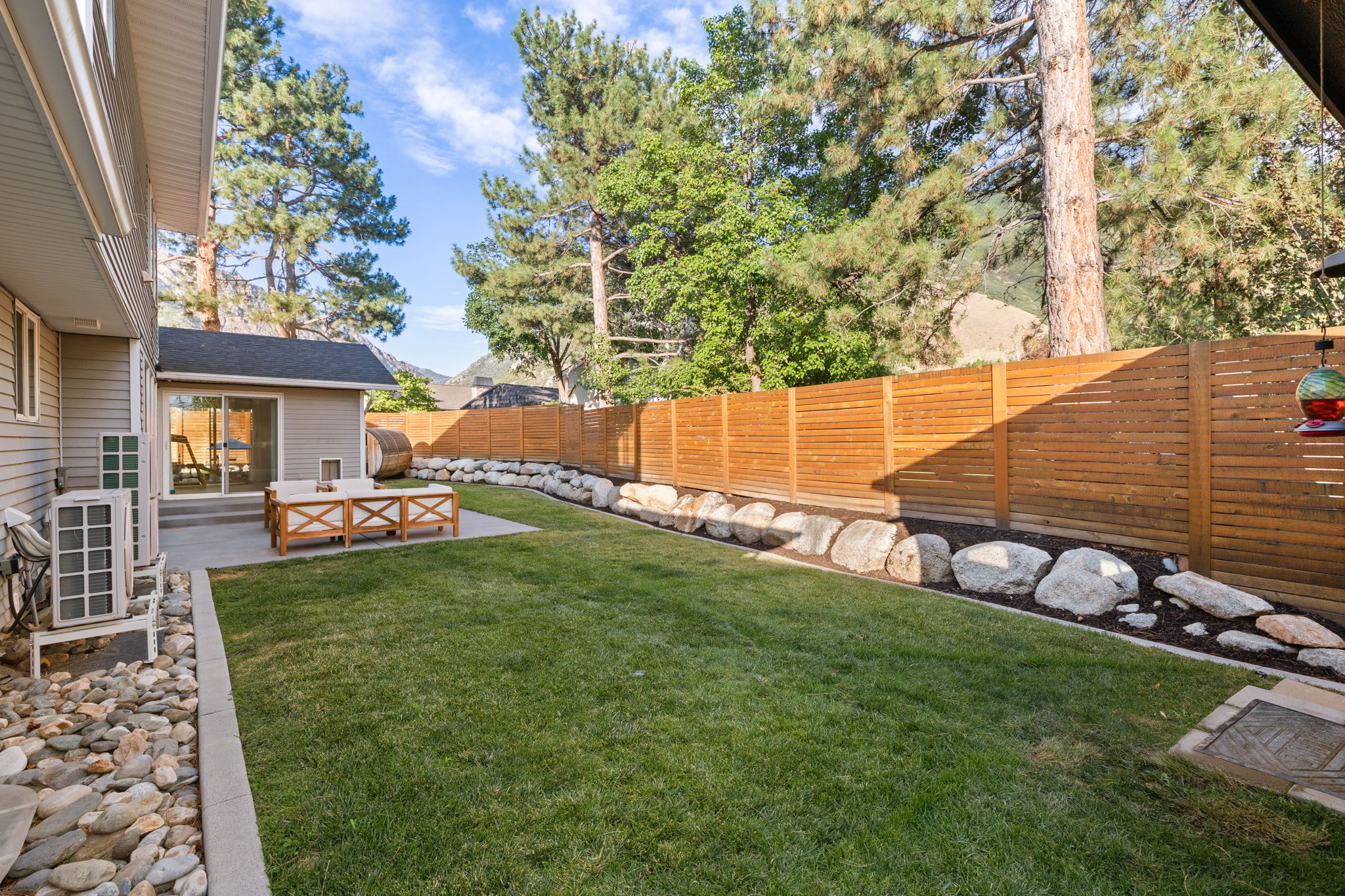 Expansive backyard featuring a lush lawn and a large concrete patio