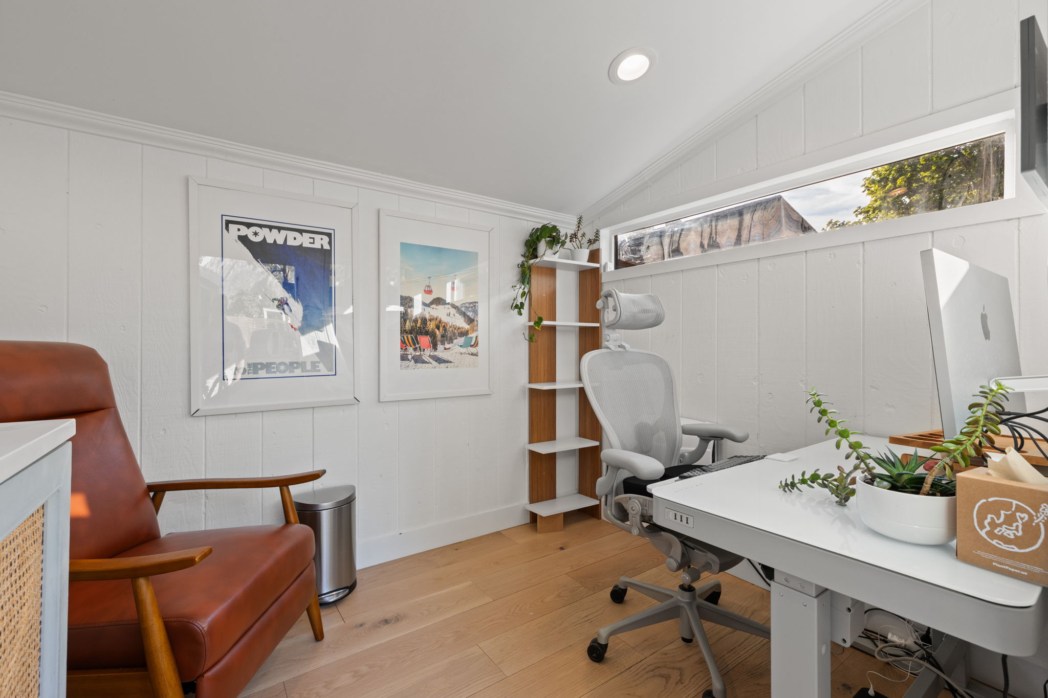 Room featuring wood-finish flooring, white shiplap walls, and a vaulted ceiling with recessed lighting