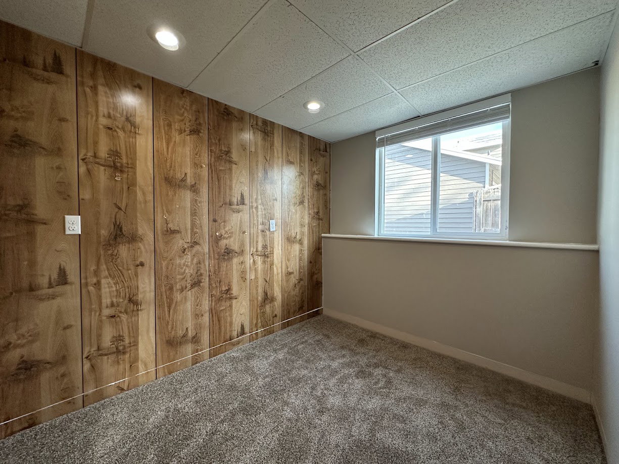 Interior room featuring wood-panel accent wall and neutral painted walls
