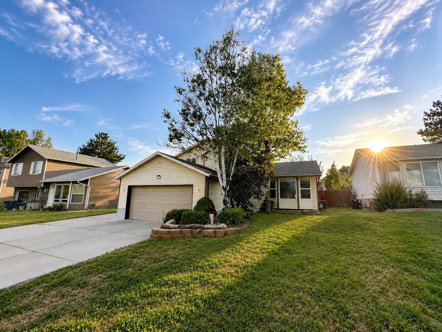 Two-story residence featuring light-colored siding, an attached garage, and a concrete driveway