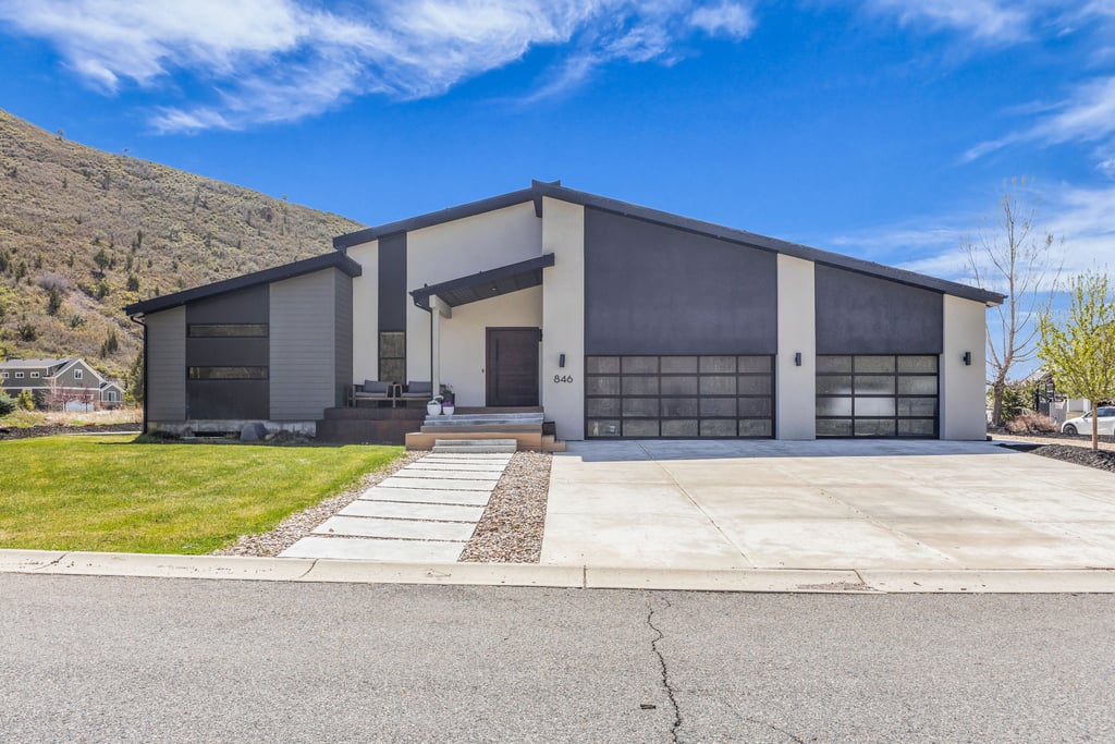 Modern dwelling featuring a sloped roofline and a two-car garage with frosted glass doors