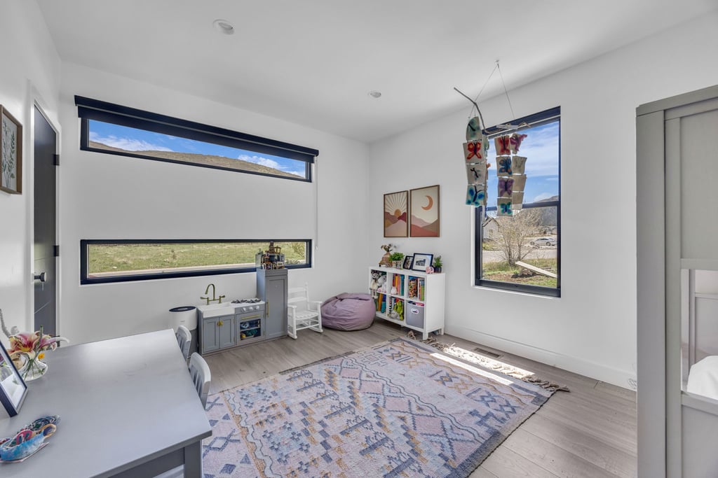 Room featuring light wood-finish flooring, white walls, recessed lighting, and contemporary black-framed windows