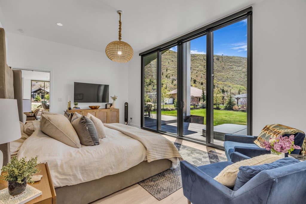 Sliding glass patio doors opening to a mountainous backdrop and a landscaped yard
