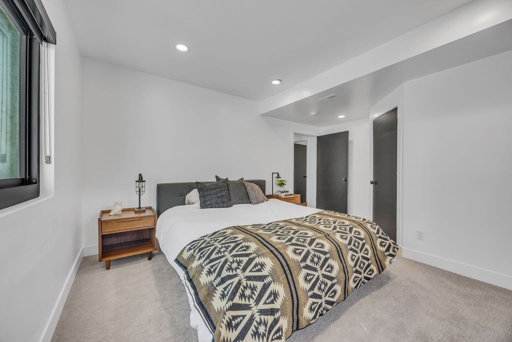 Bedroom featuring recessed lighting, light-toned carpet flooring, and a large window with roller shades