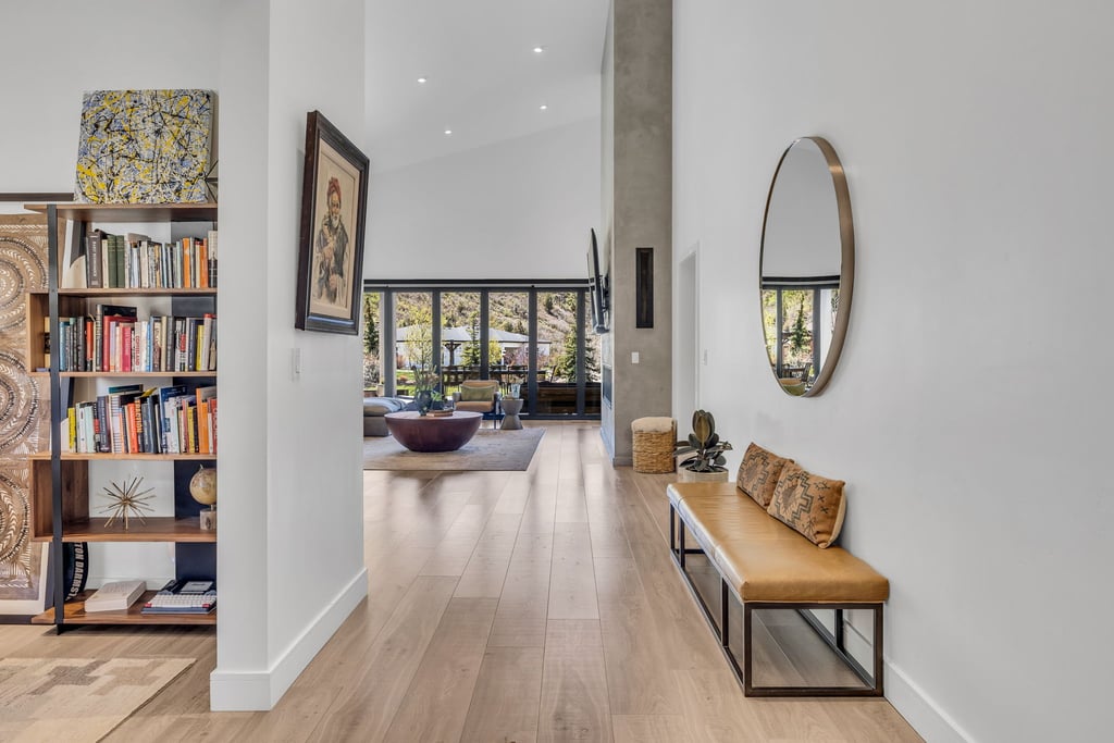 Spacious entry hallway featuring wood-finish flooring, a built-in shelving unit, and a vaulted ceiling