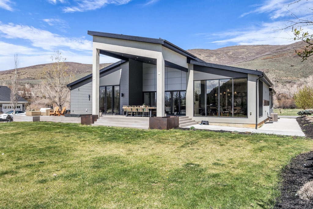 Contemporary residential exterior featuring a prominent angled roofline and expansive glass windows