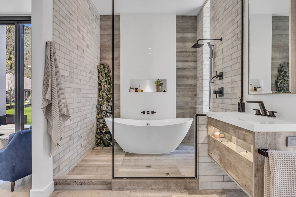 Modern bathroom featuring a freestanding soaking tub, a frameless glass shower enclosure, and a wall-mounted vanity with integrated lighting