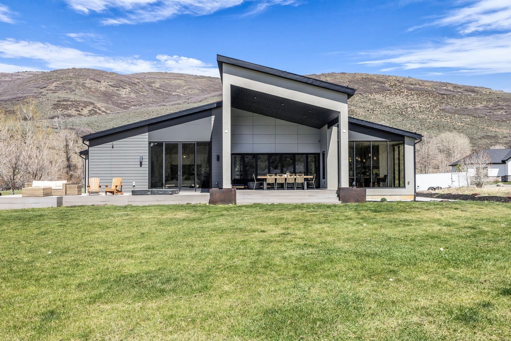 Modern architectural design with a prominent covered patio area and expansive glass doors