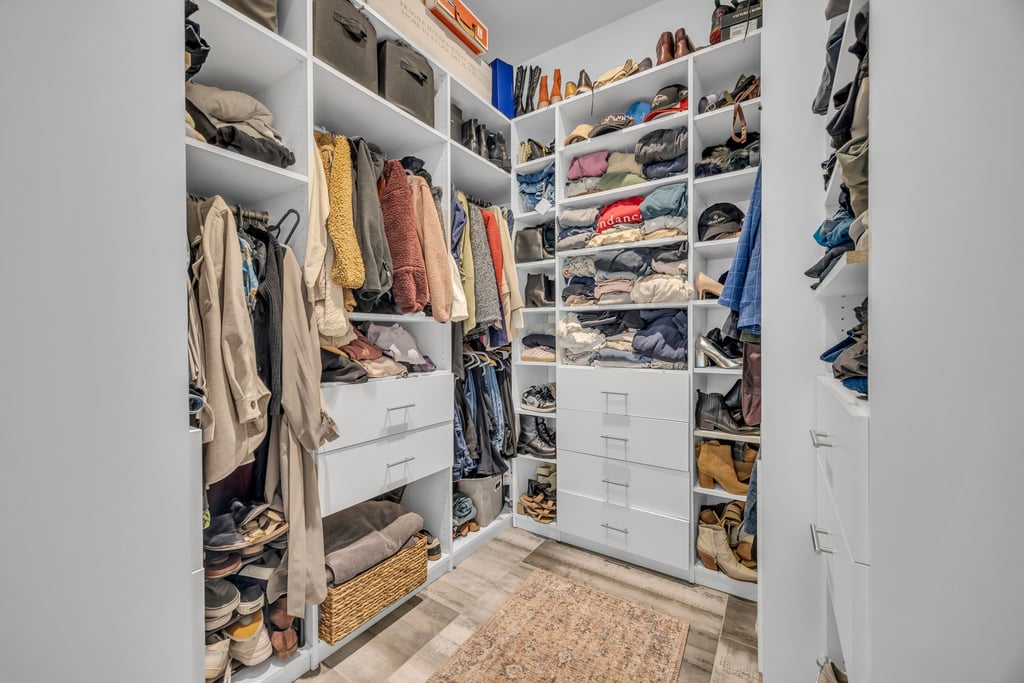 Custom closet system featuring extensive shelving, multiple hanging rods, and integrated drawers