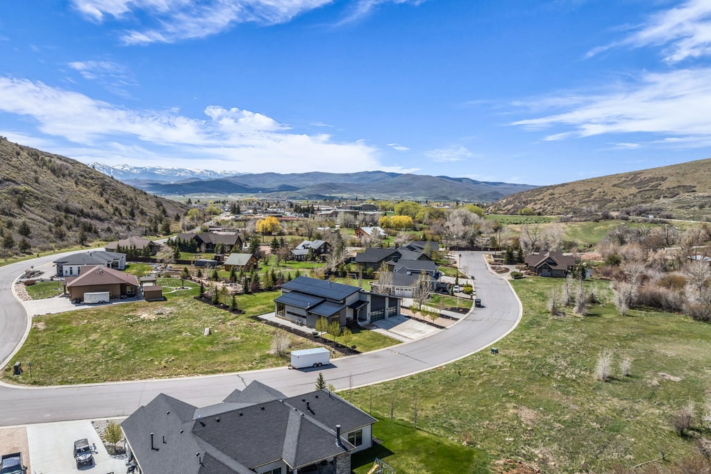 Mountainous landscape featuring a residential area with varied home styles and green spaces