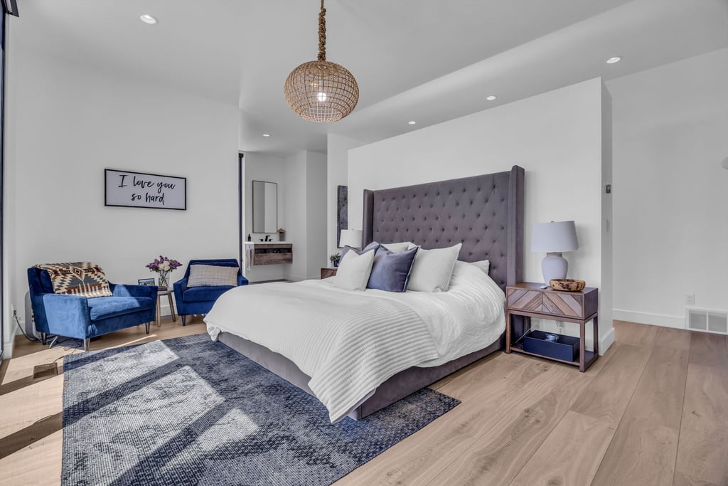 Spacious room featuring light wood-finish flooring, recessed lighting, a decorative hanging fixture, and a partial wall element