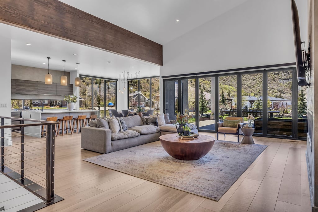 Spacious living area featuring wood-finish flooring, a vaulted ceiling, and an exposed wood beam