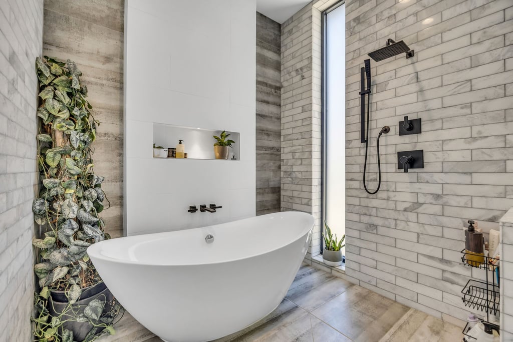 Modern bathroom featuring a freestanding soaking tub, matte black fixtures, a vertical window, a built-in recessed shelf, and subway-style wall tiling