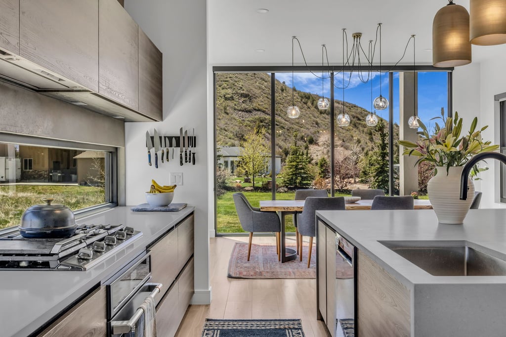 Contemporary kitchen with integrated appliances, wood-finish cabinetry, and light countertops