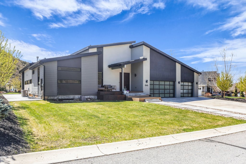 Contemporary exterior featuring a multi-tone facade, prominent angled rooflines, and a two-car garage with frosted glass doors