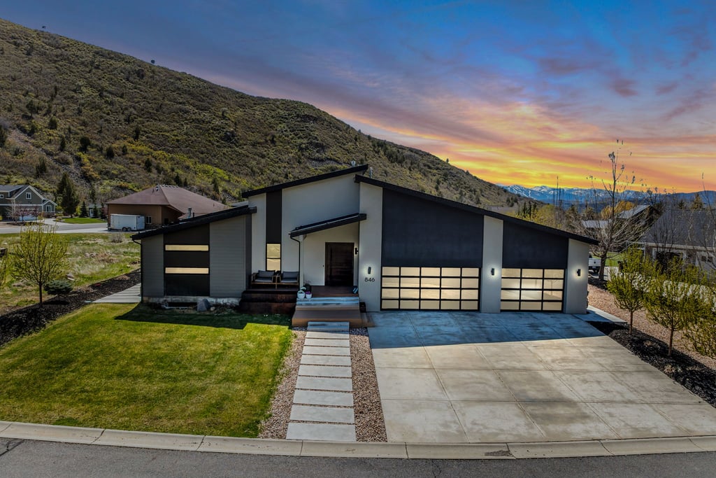 Contemporary architecture featuring a low-slope roofline and a two-car garage with frosted glass doors