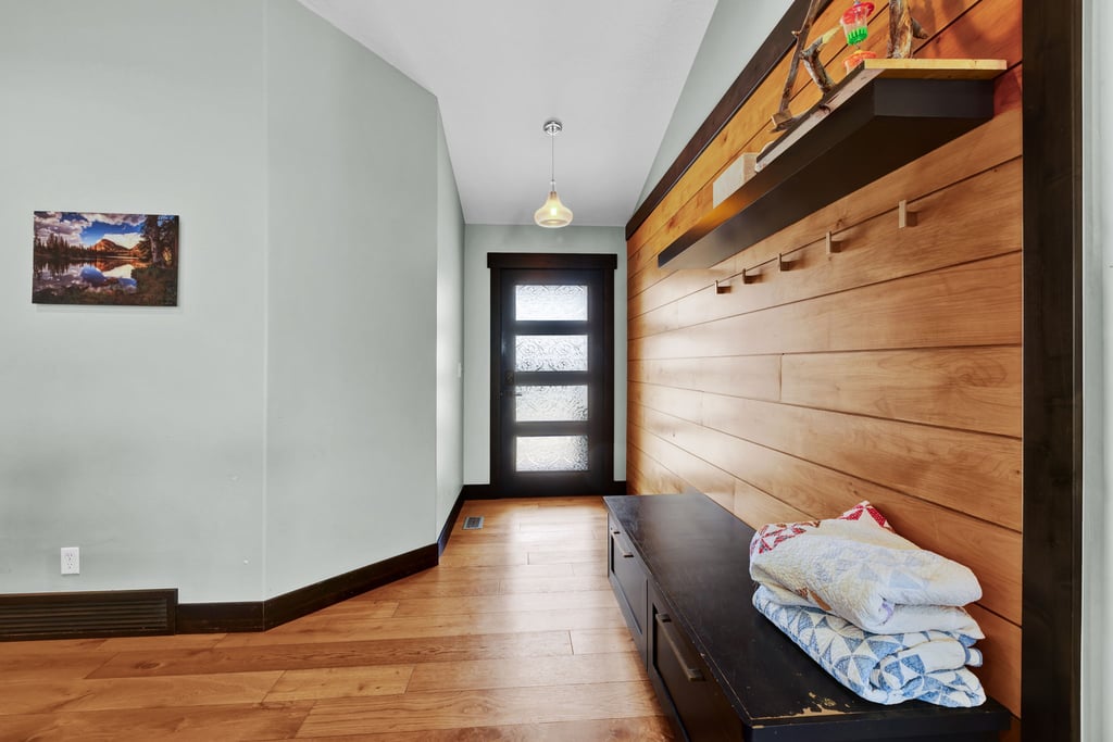 Entryway featuring a wood-finish accent wall, built-in shelving, hardwood flooring, and a modern door with frosted glass panels
