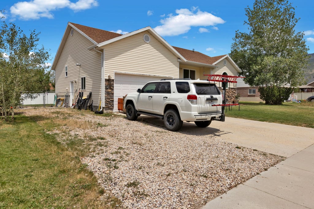 Cream-colored siding exterior featuring a multi-gable roofline and an attached garage with a white overhead door