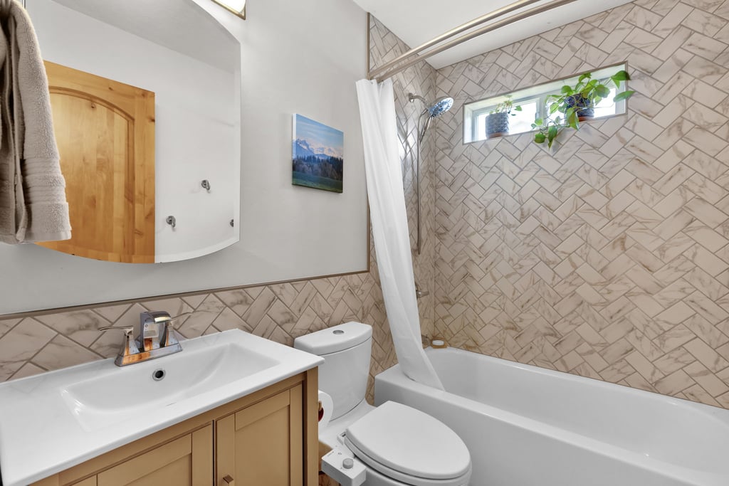 Bathroom featuring a vanity with a rectangular sink, wood-finish cabinetry, and chrome faucet