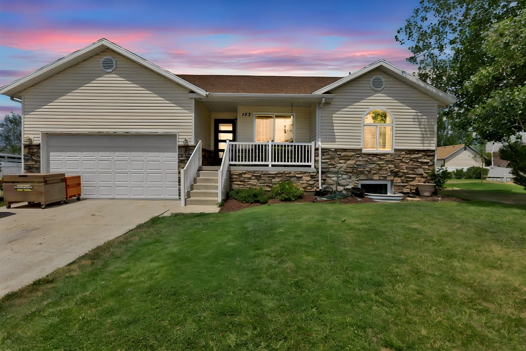 Exterior facade featuring light-colored siding and stone veneer accents