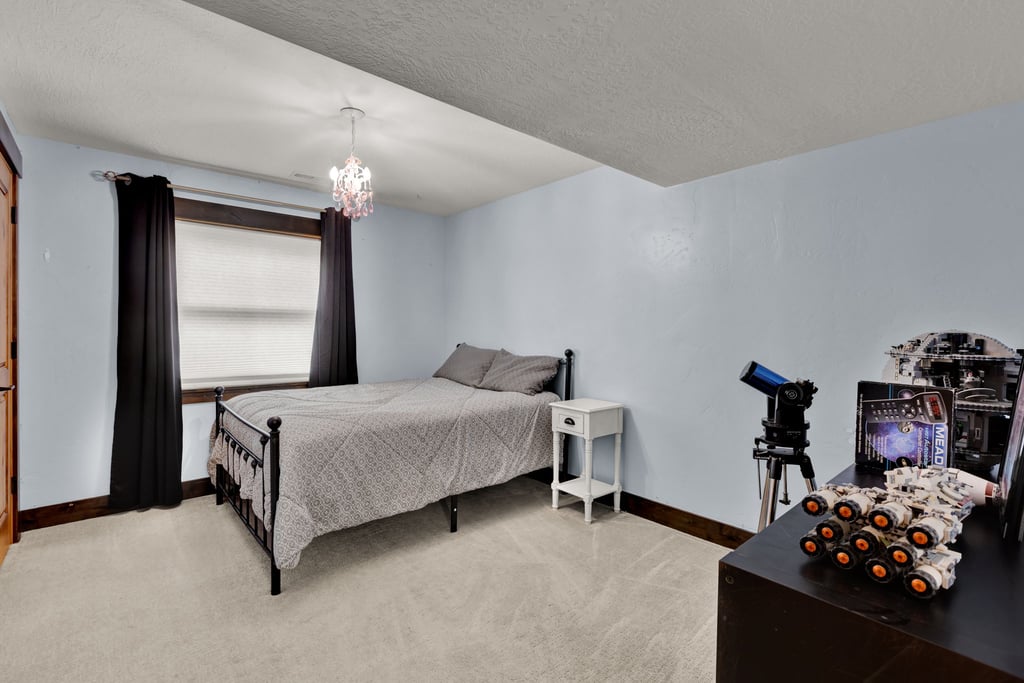 Bedroom featuring light blue walls and neutral carpeting