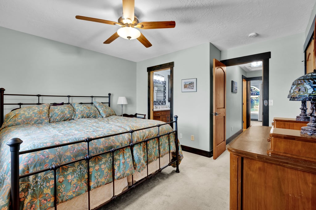 Spacious room featuring light-colored walls, ceiling fan with integrated lighting, wood-finish trim, and carpet flooring