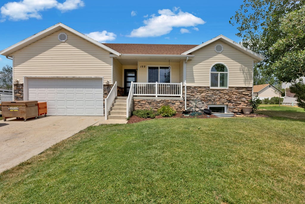 Ranch-style exterior with stone veneer accents and light-colored siding