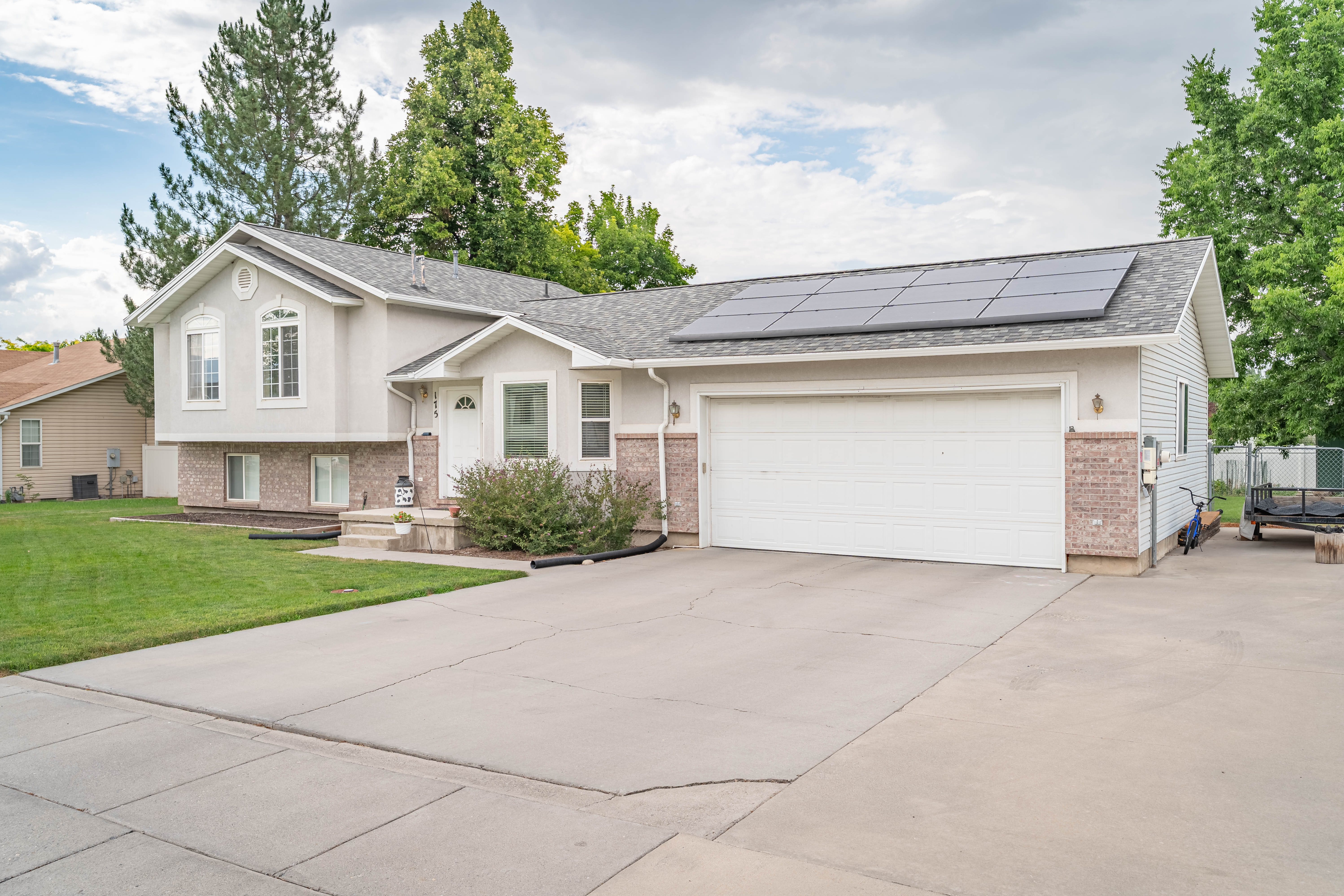 Split-level residence featuring a two-car garage with solar panels