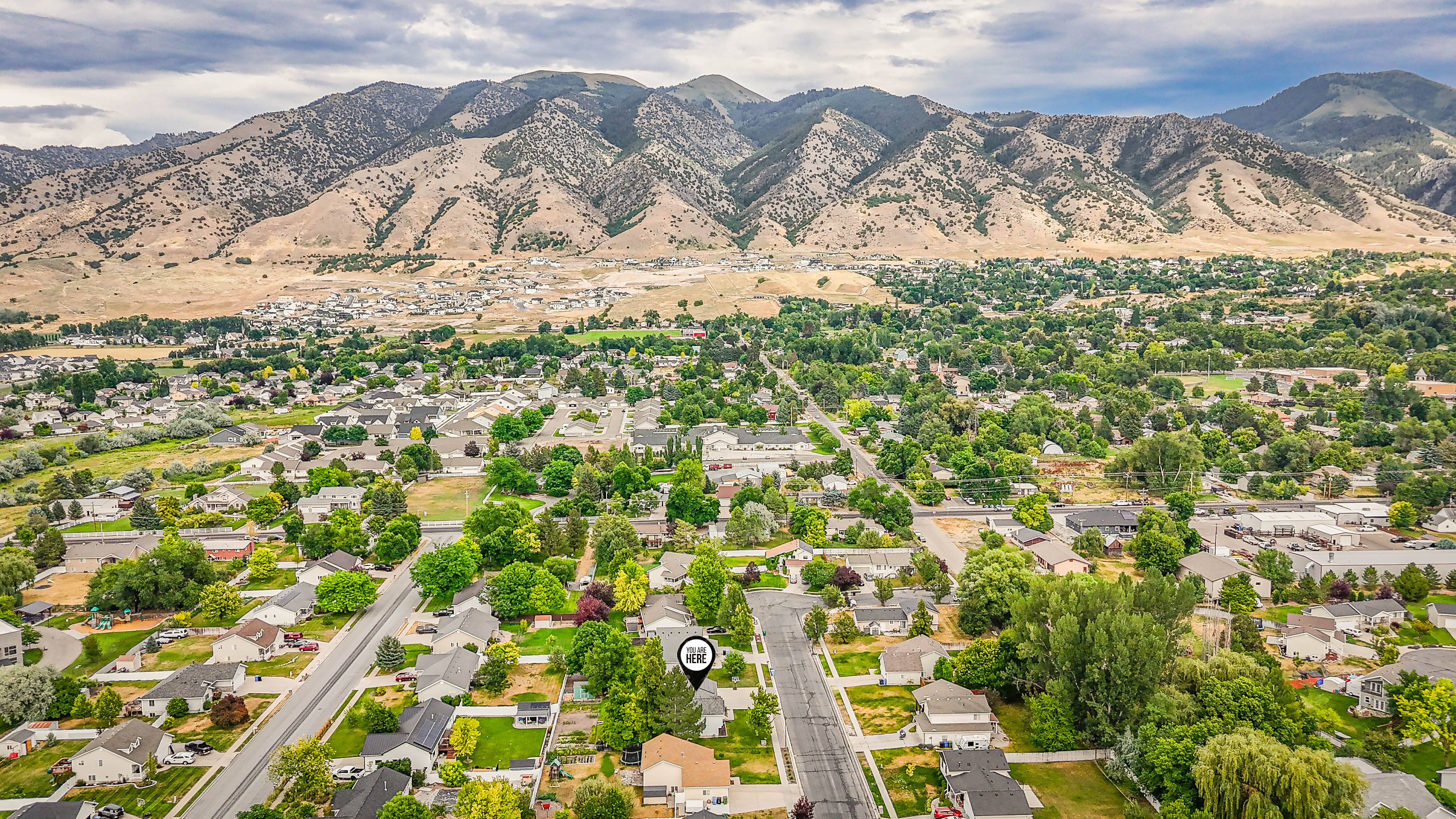 Aerial perspective showcasing a residential area set against a mountainous backdrop
