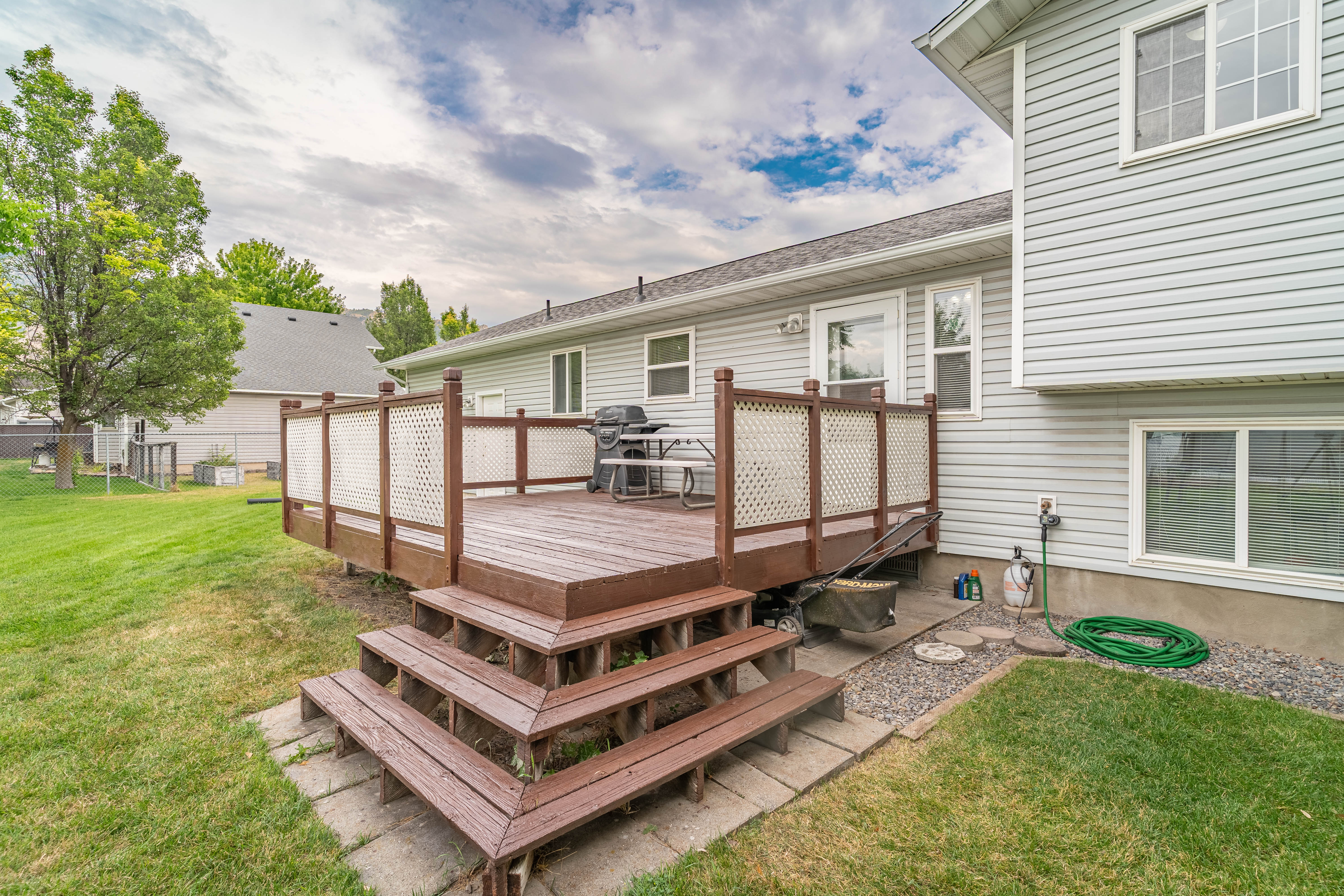 Spacious rear deck featuring warm wood-finish decking and lattice railing