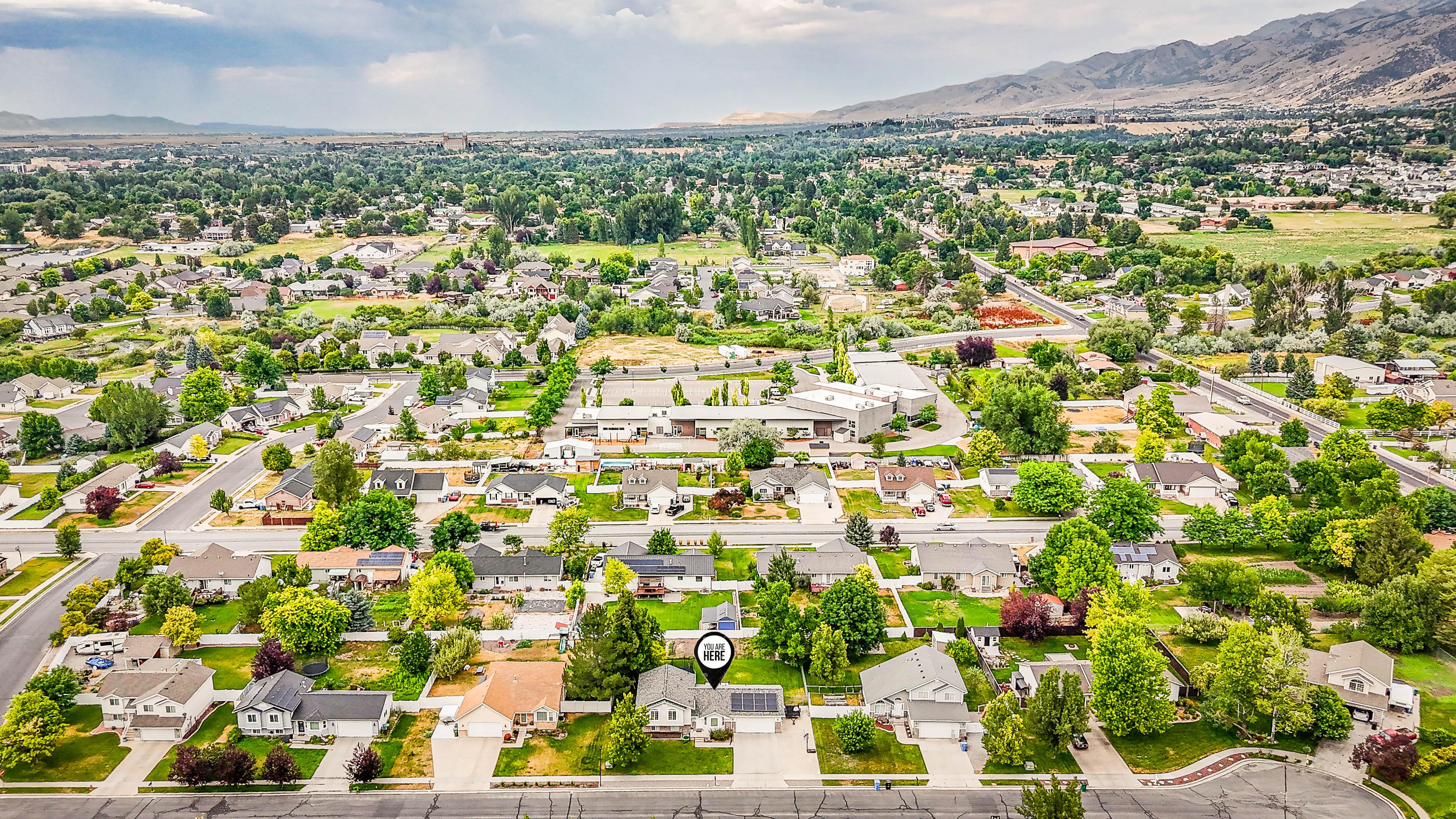 Aerial perspective of a residential neighborhood with a mountain range backdrop