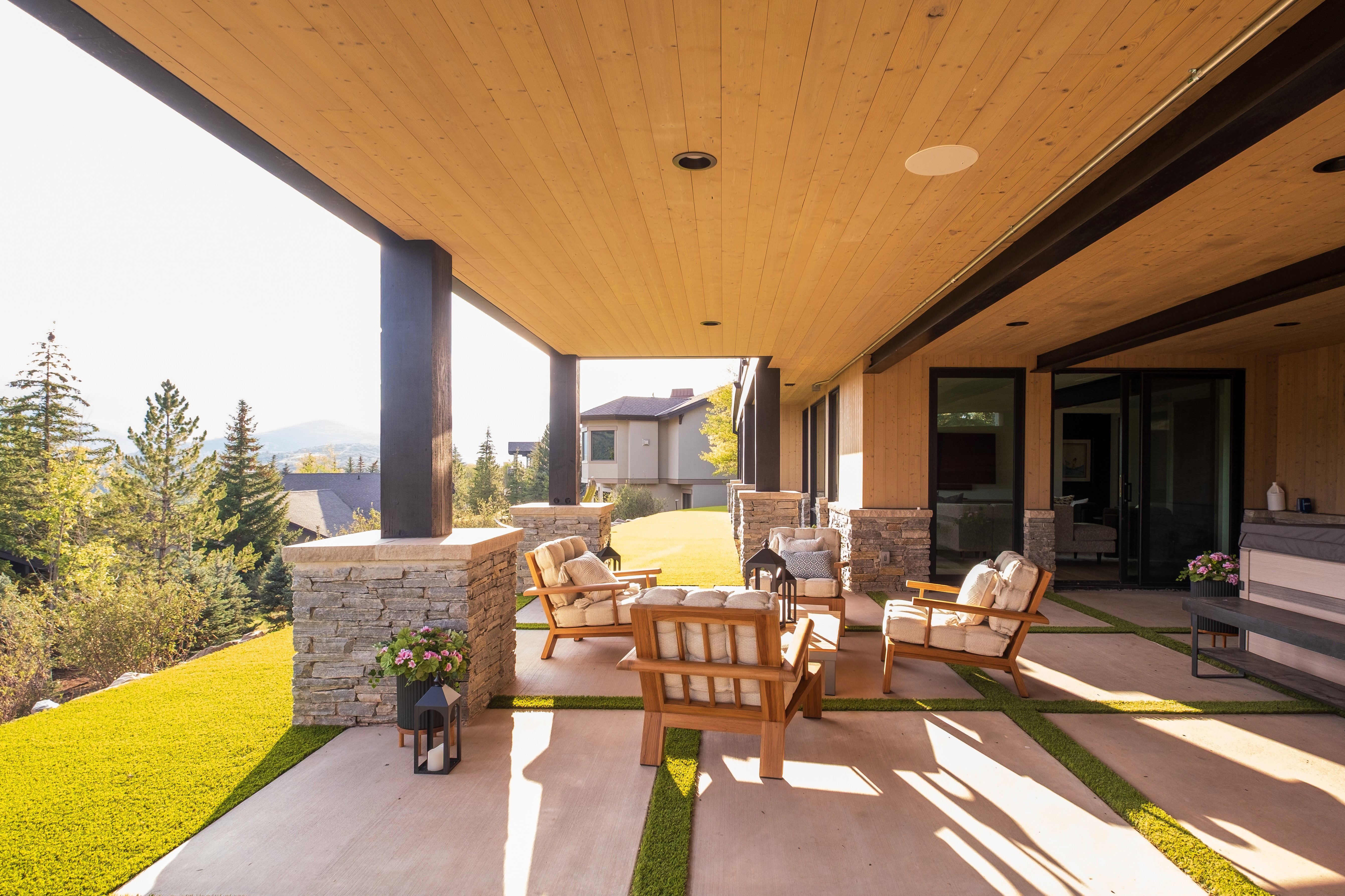 Expansive covered patio featuring a wood-panel ceiling, recessed lighting, and exposed structural beams