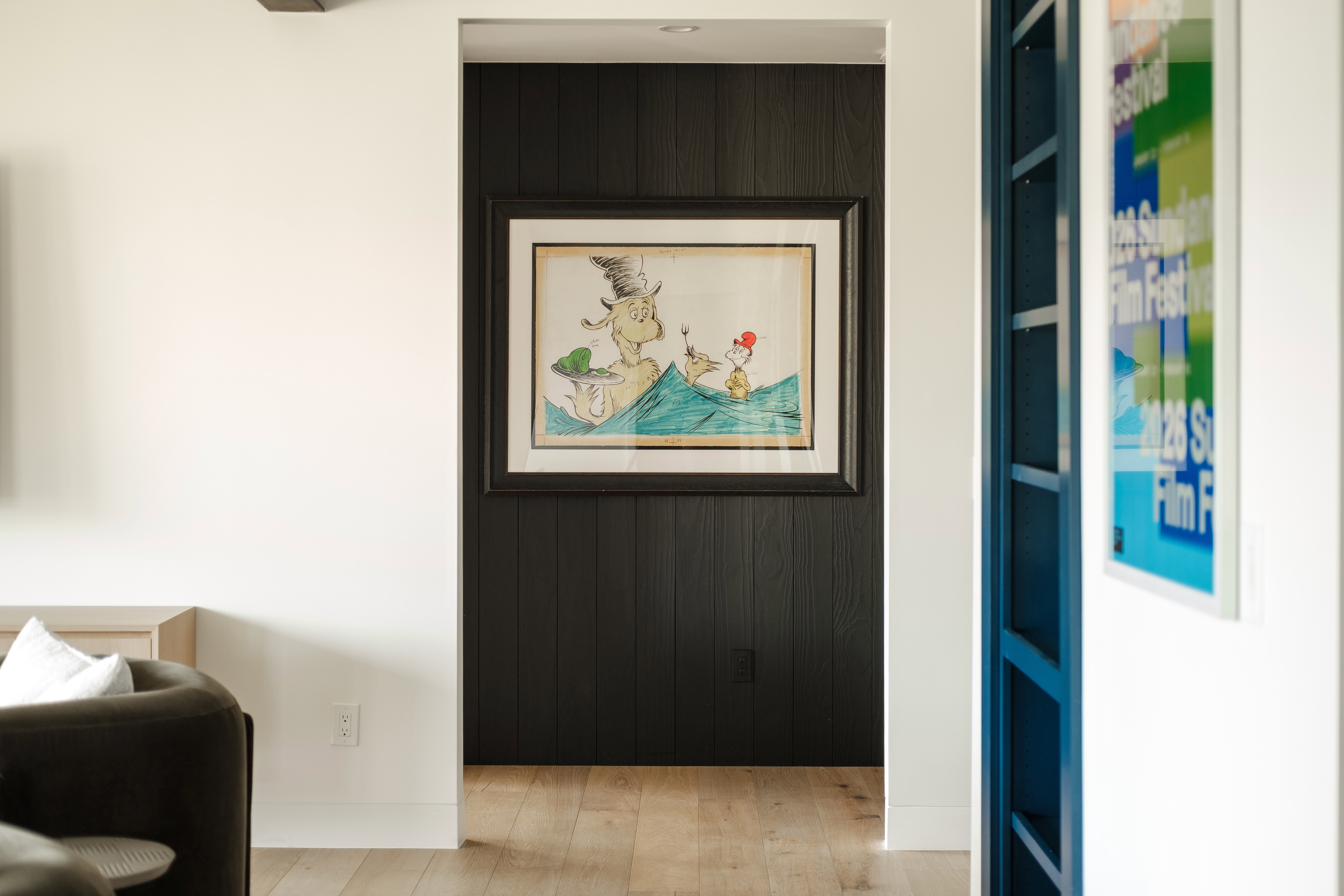 Hallway with dark wood-paneled accent wall and light wood-finish flooring