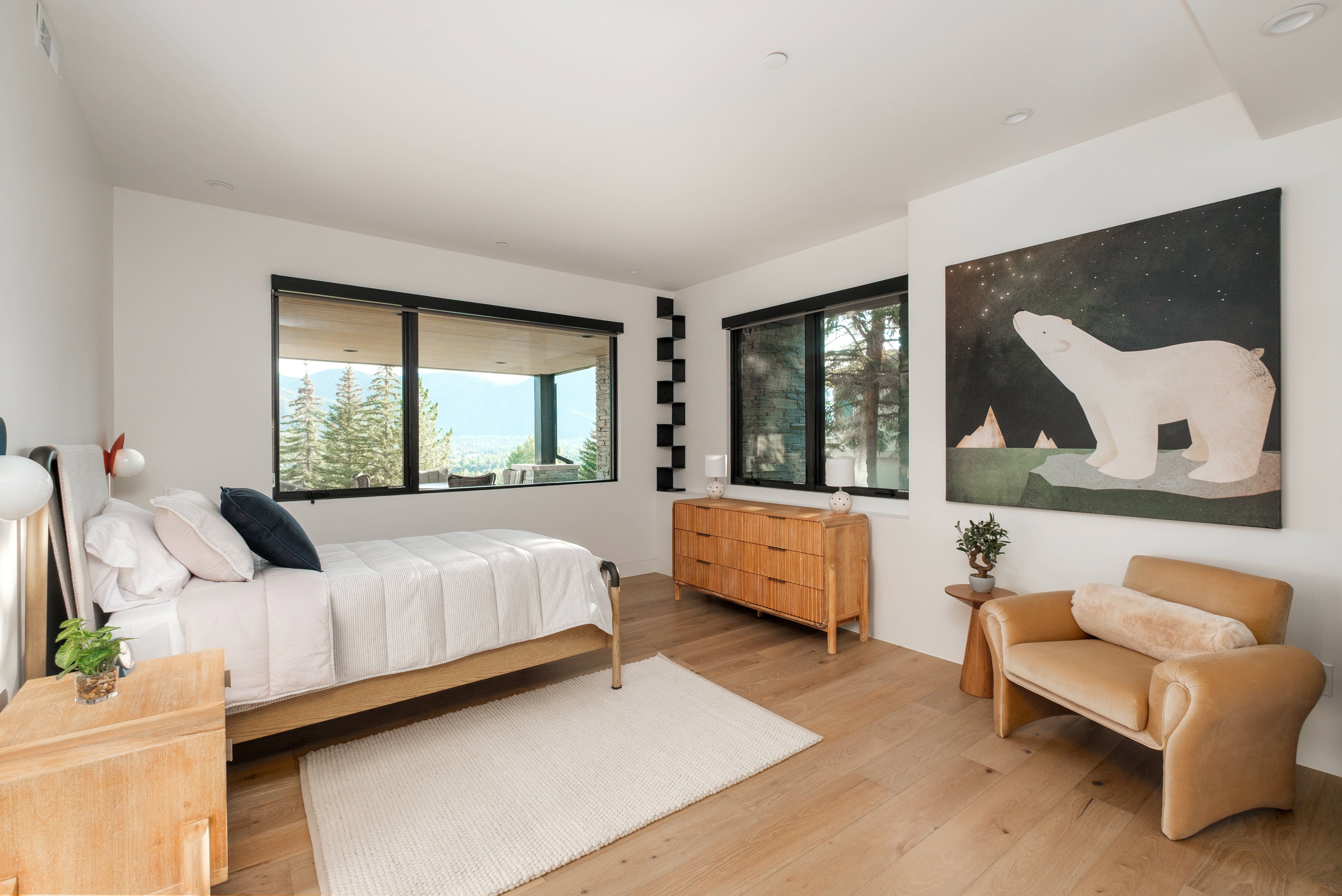 Bright bedroom featuring expansive windows, wood-finish flooring, a neutral color palette, recessed lighting, and a contemporary wall fixture