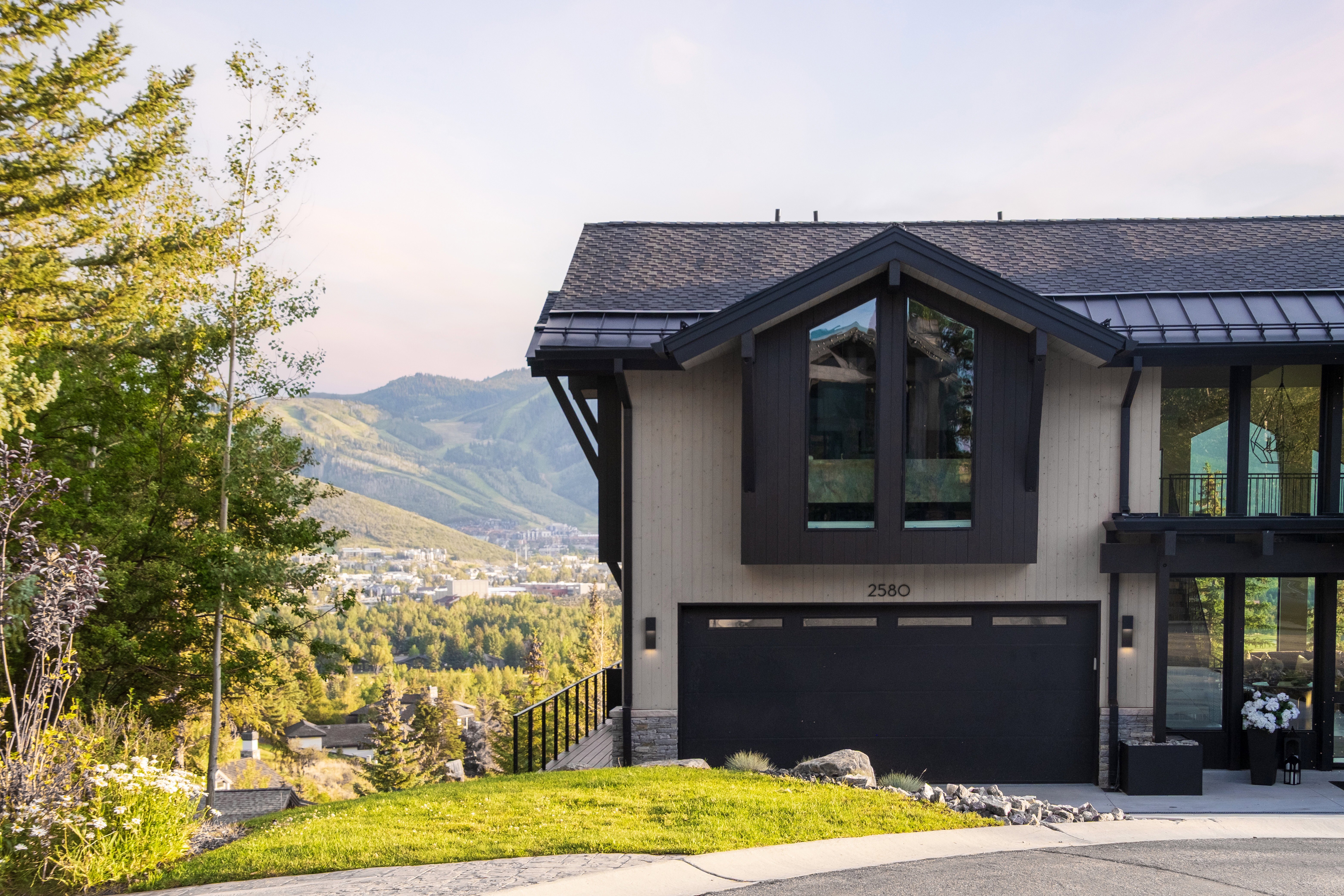 Modern mountain-style exterior featuring a dark grey metal roof and complementary black trim