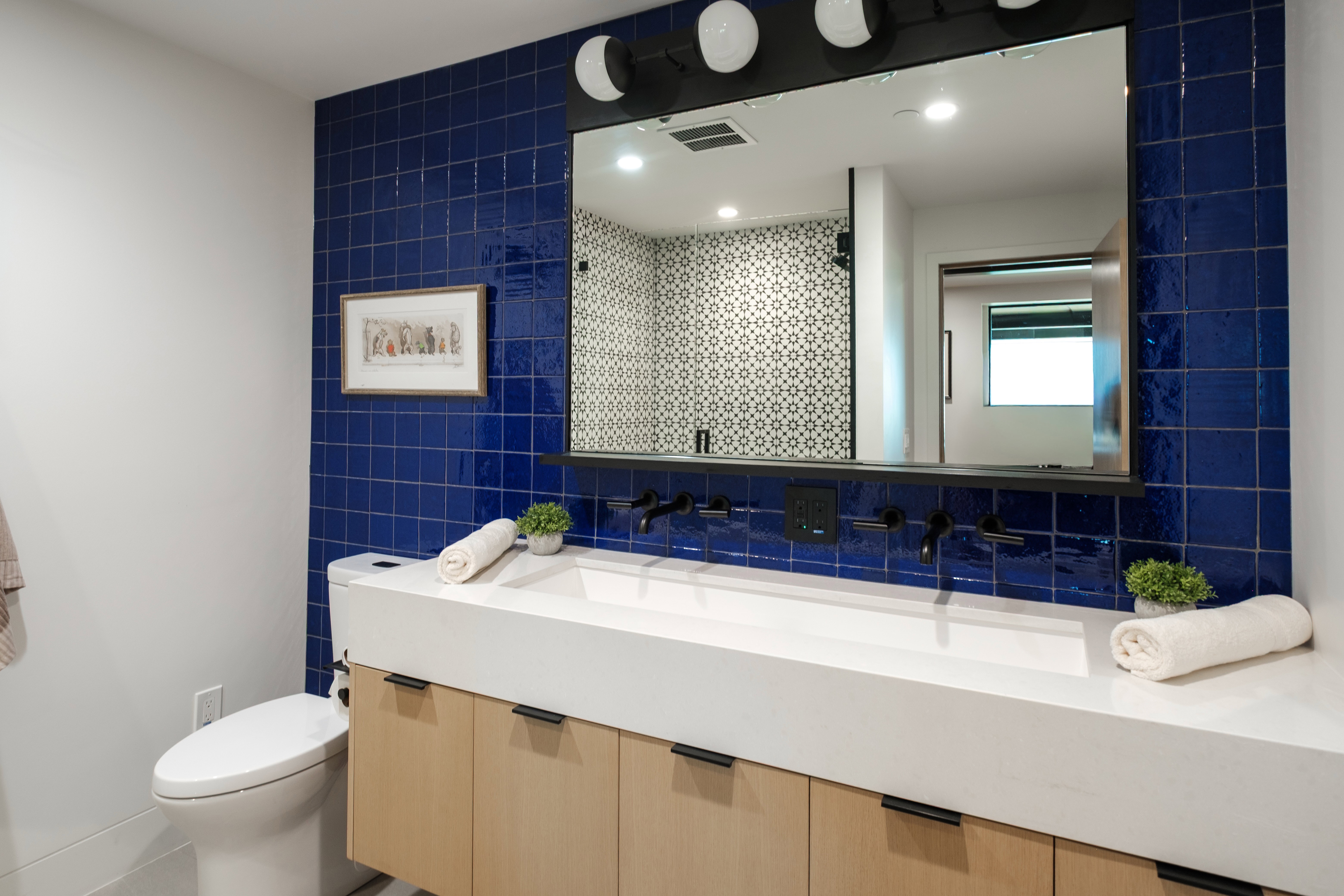 Custom vanity with dual integrated sinks and light wood-finish cabinetry
