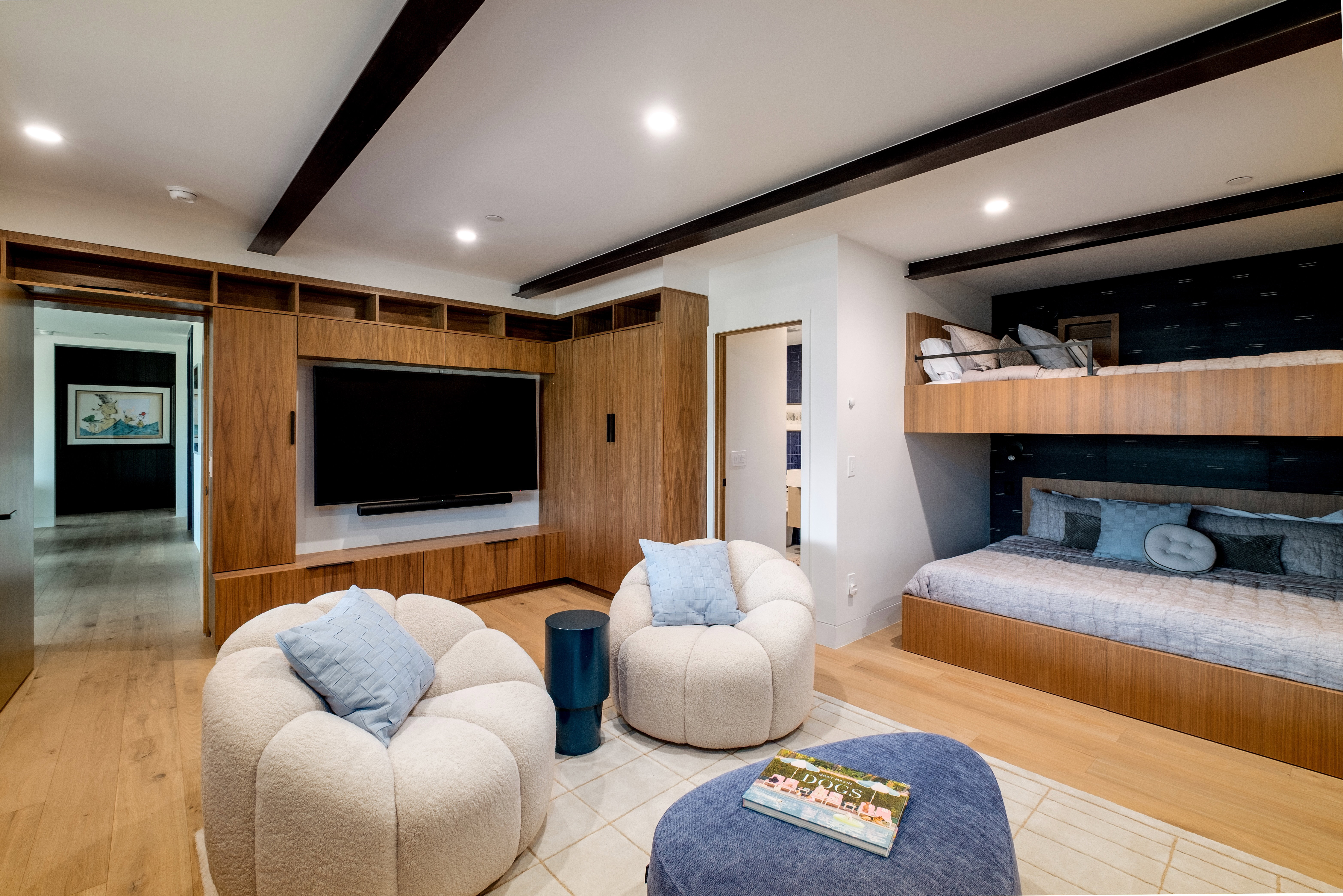 Integrated entertainment wall with built-in cabinetry and shelving, exposed ceiling beams, recessed lighting, and wood-finish flooring