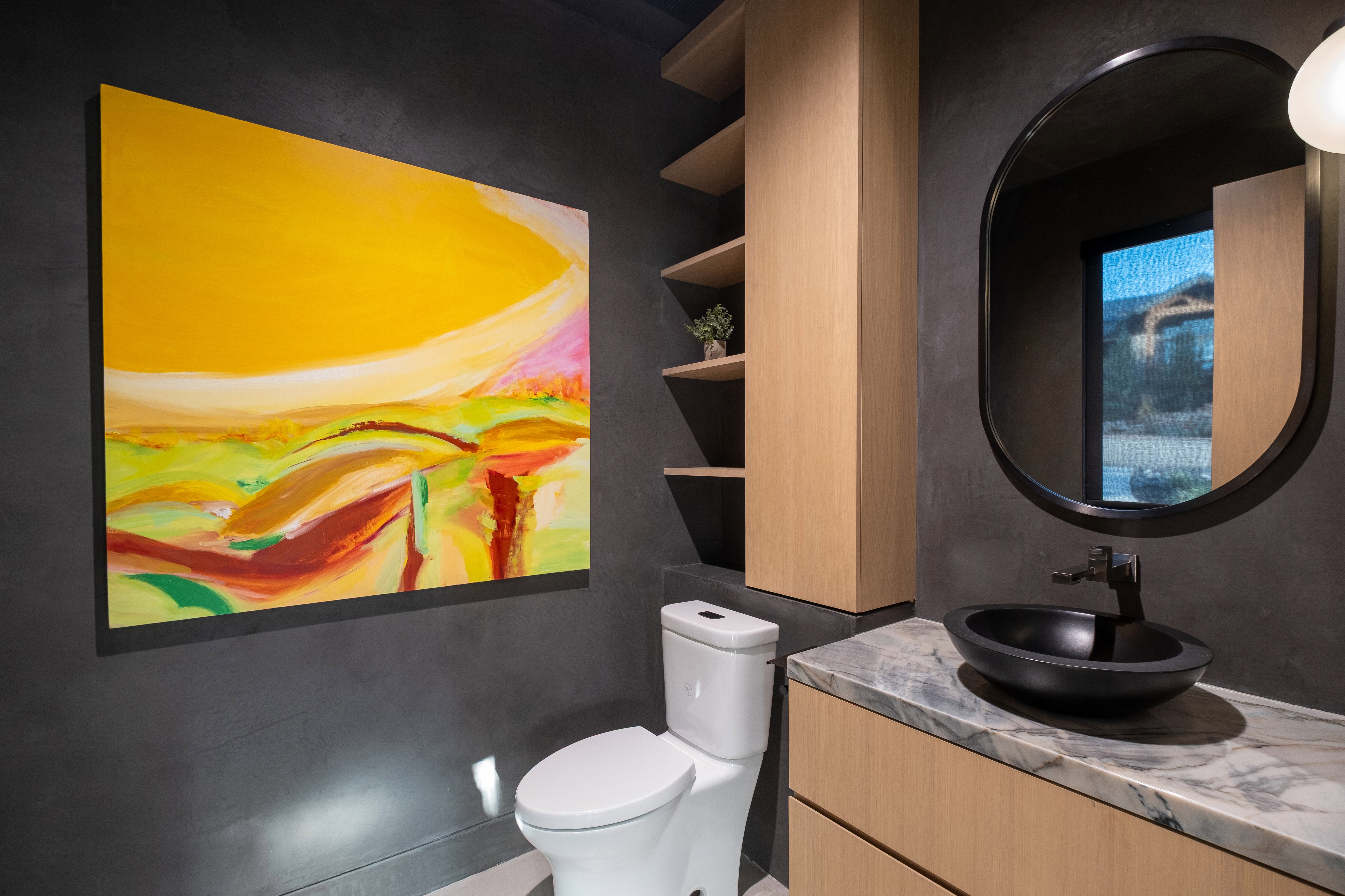 Modern vanity featuring a black vessel sink, black faucet, and stone countertop