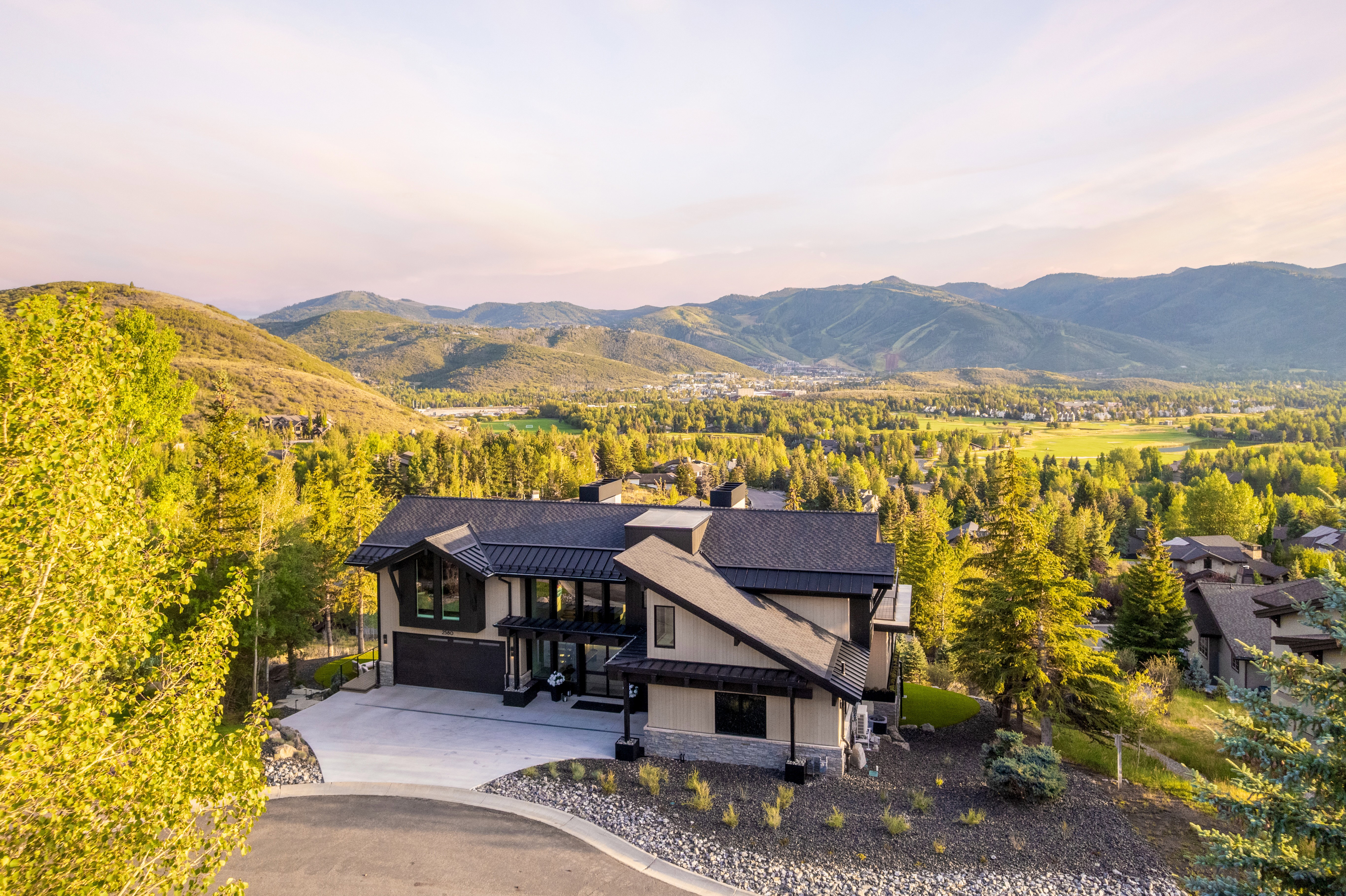 Modern architectural home featuring a multi-level design, dark-pitched roof, and extensive windowing