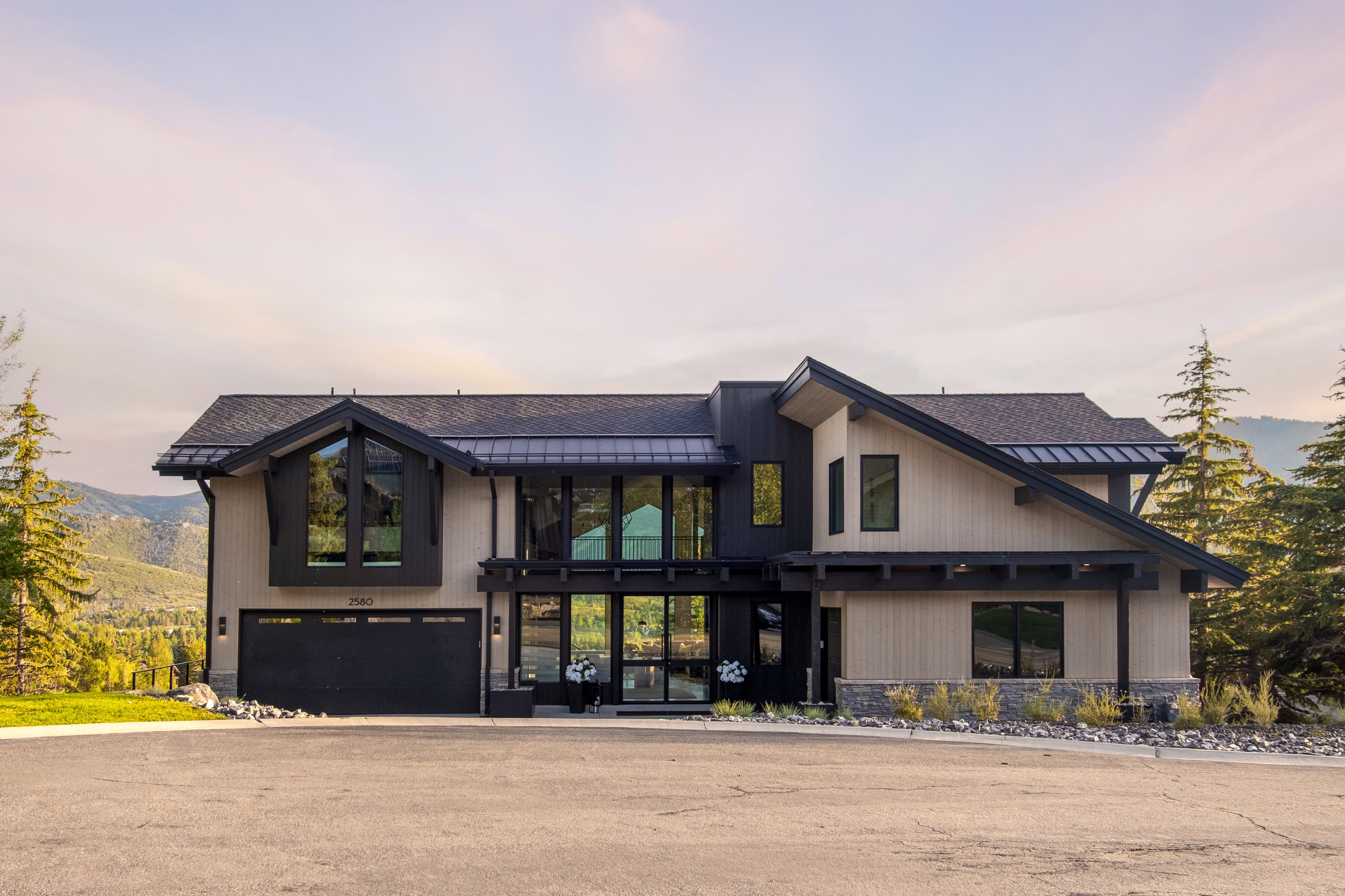 Modern alpine residence featuring a multi-gabled roofline and a neutral-toned facade with dark trim