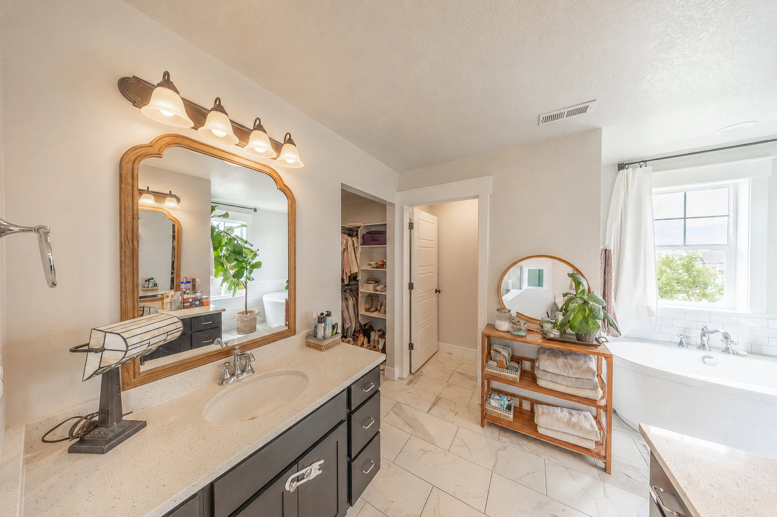 Bathroom vanity featuring a light-colored countertop, undermount sink, and dark cabinetry with brushed nickel hardware