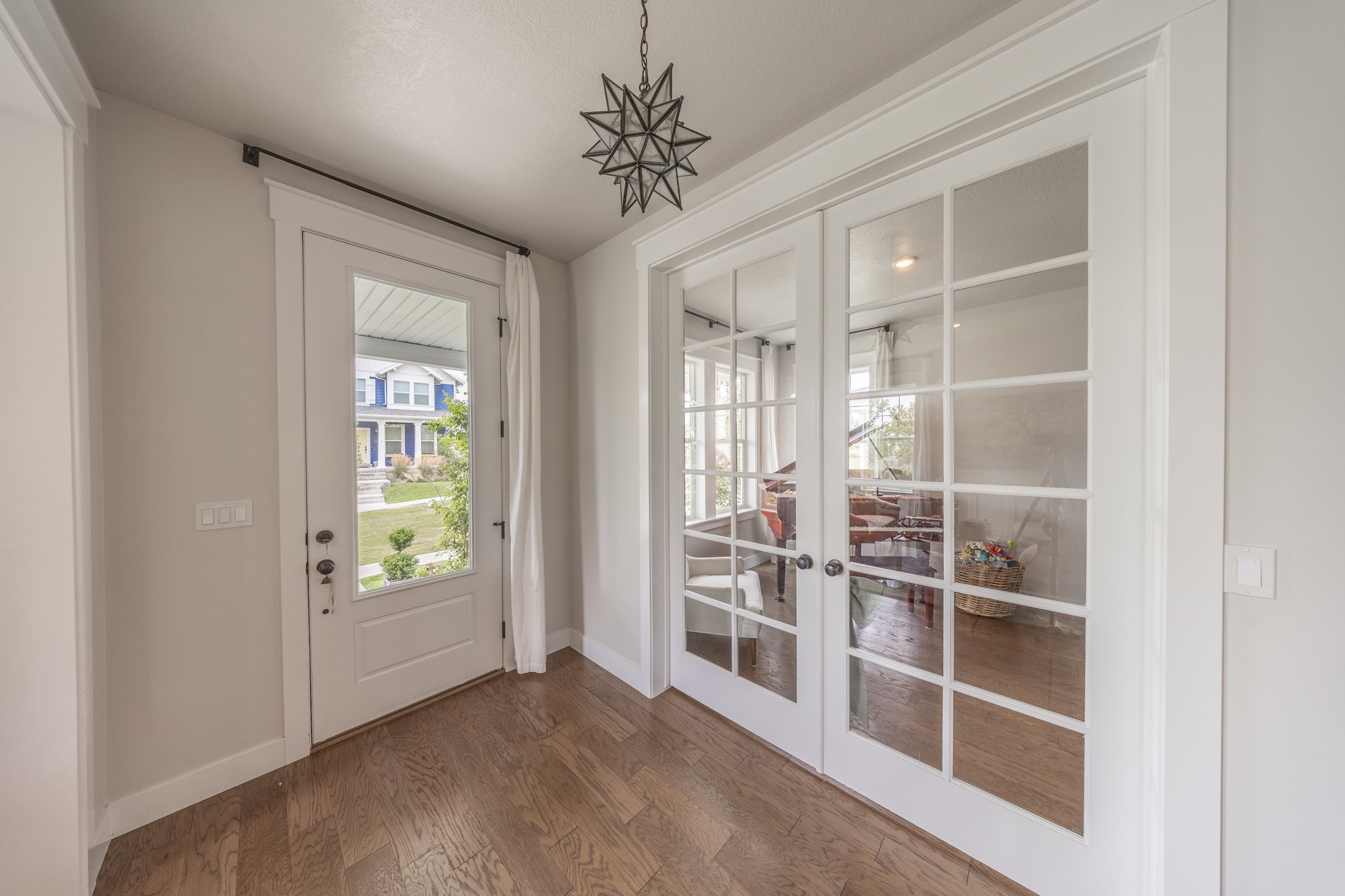 Entryway featuring wood-finish flooring and a white front door with an integrated window panel