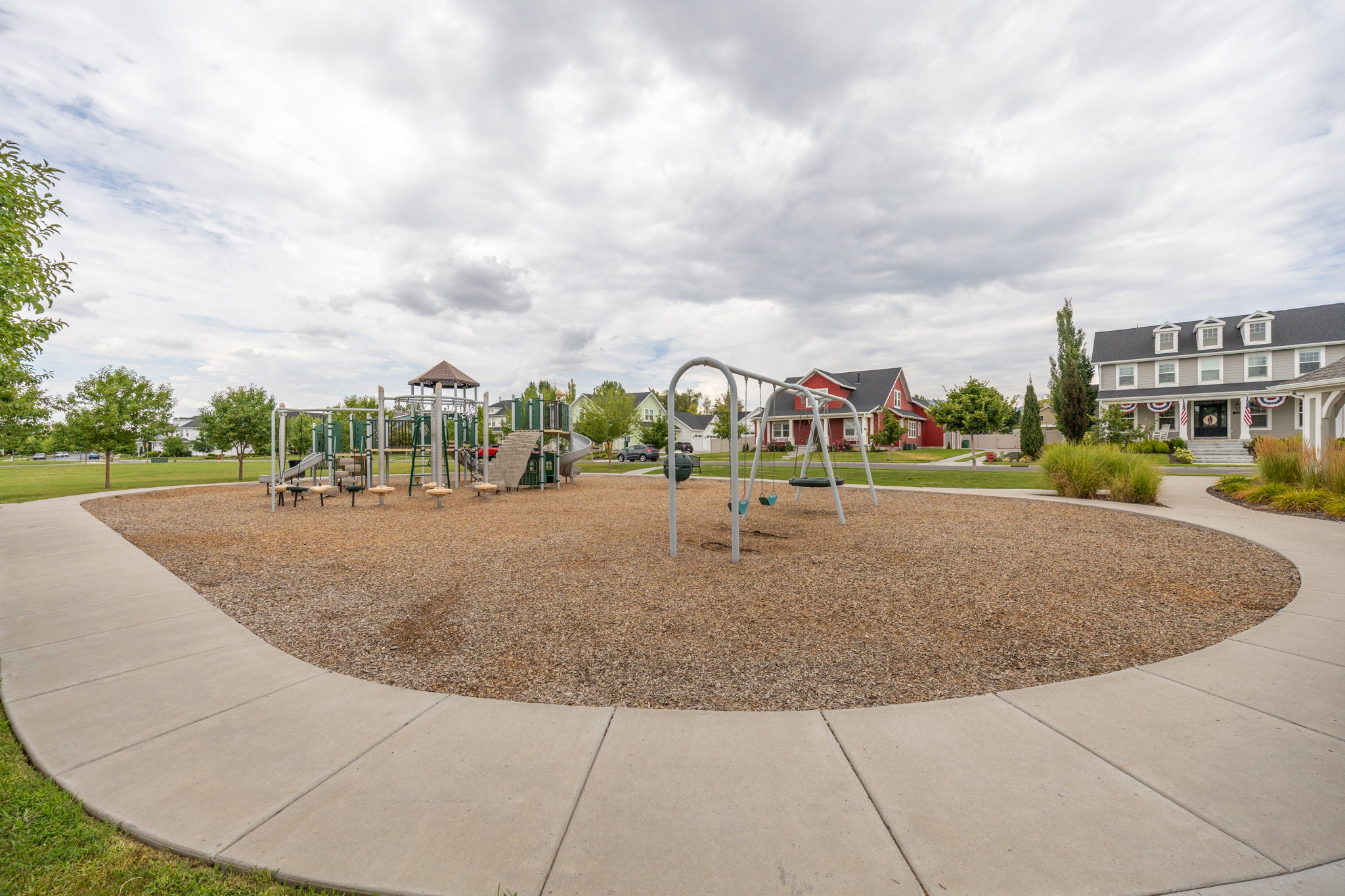 Community park featuring play structures, swings, and wood chip surfacing