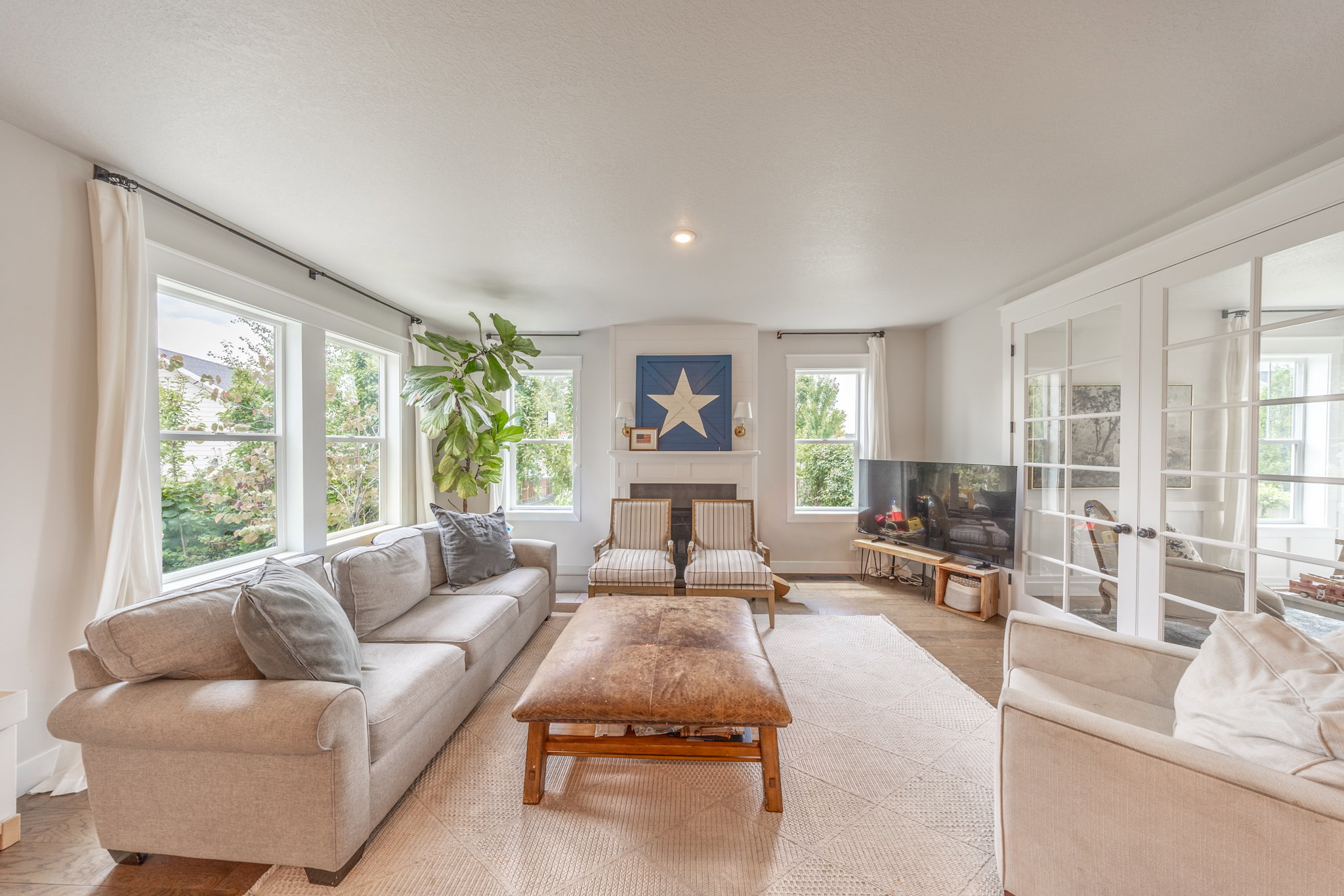 Spacious room featuring multiple windows, white trim, and a decorative fireplace