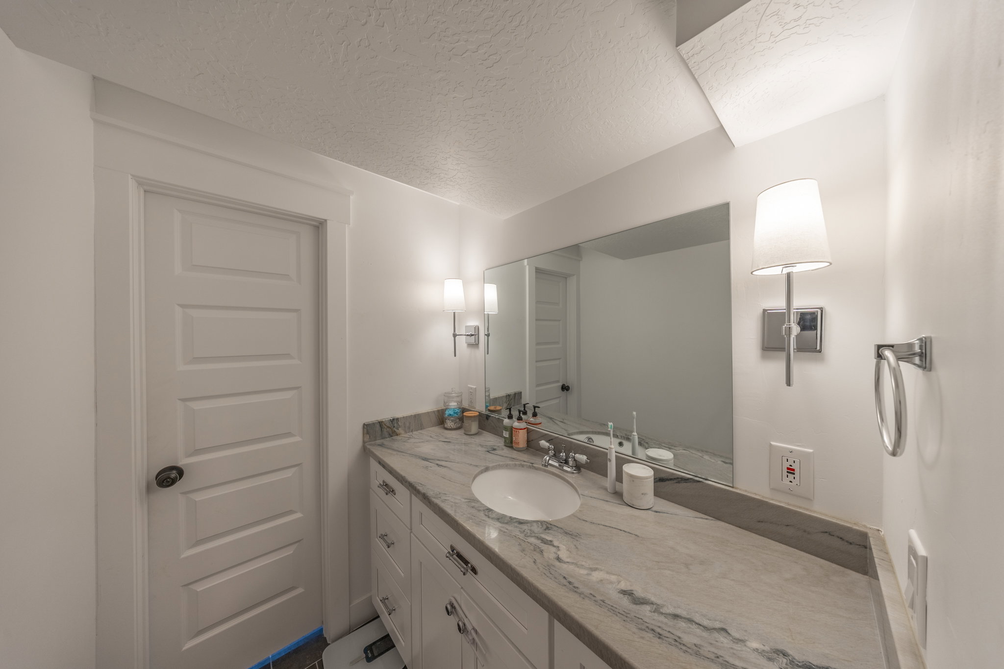 Bathroom vanity featuring a single integrated sink, stone countertop, and custom cabinetry