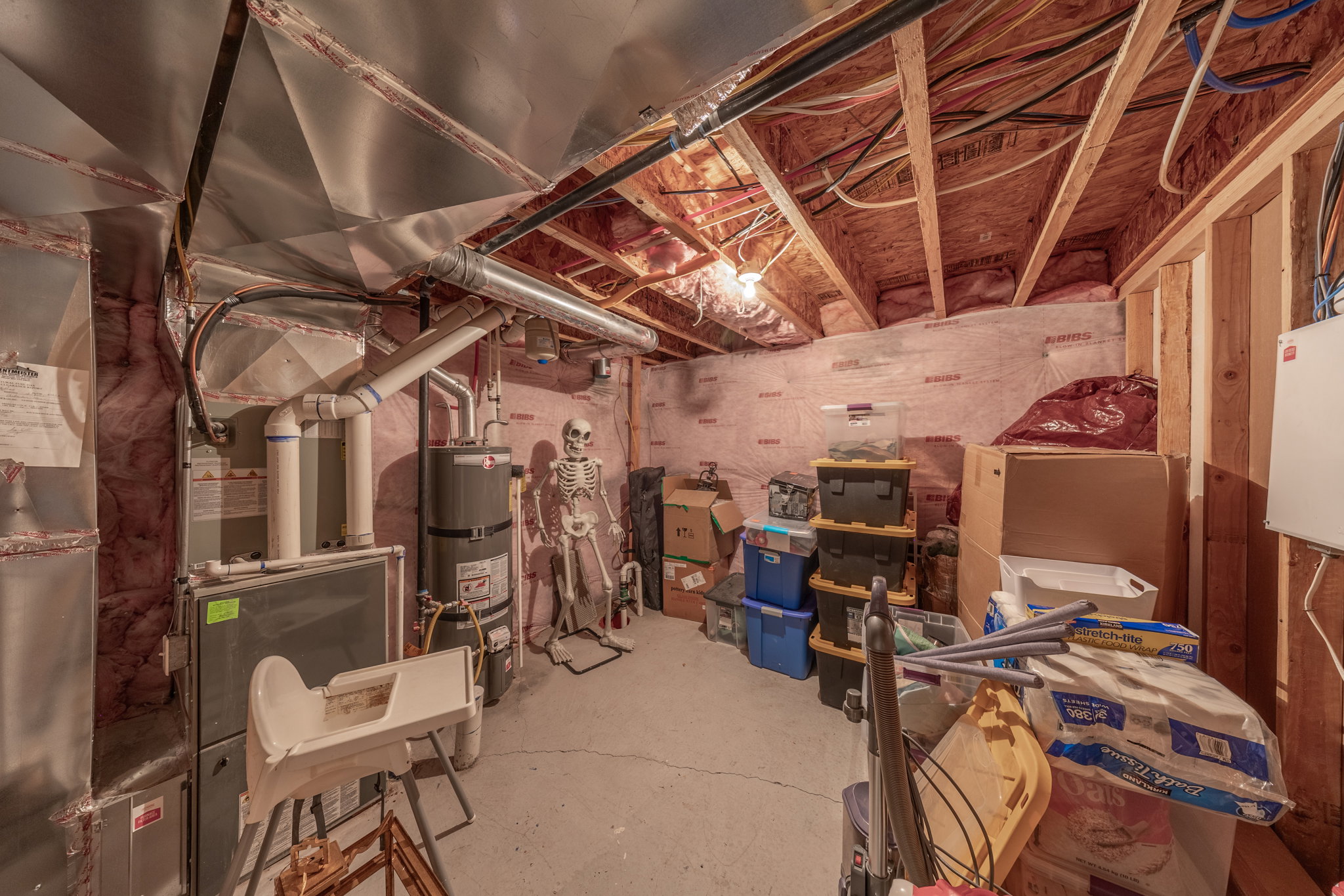 Unfinished basement with exposed wooden joists and framing