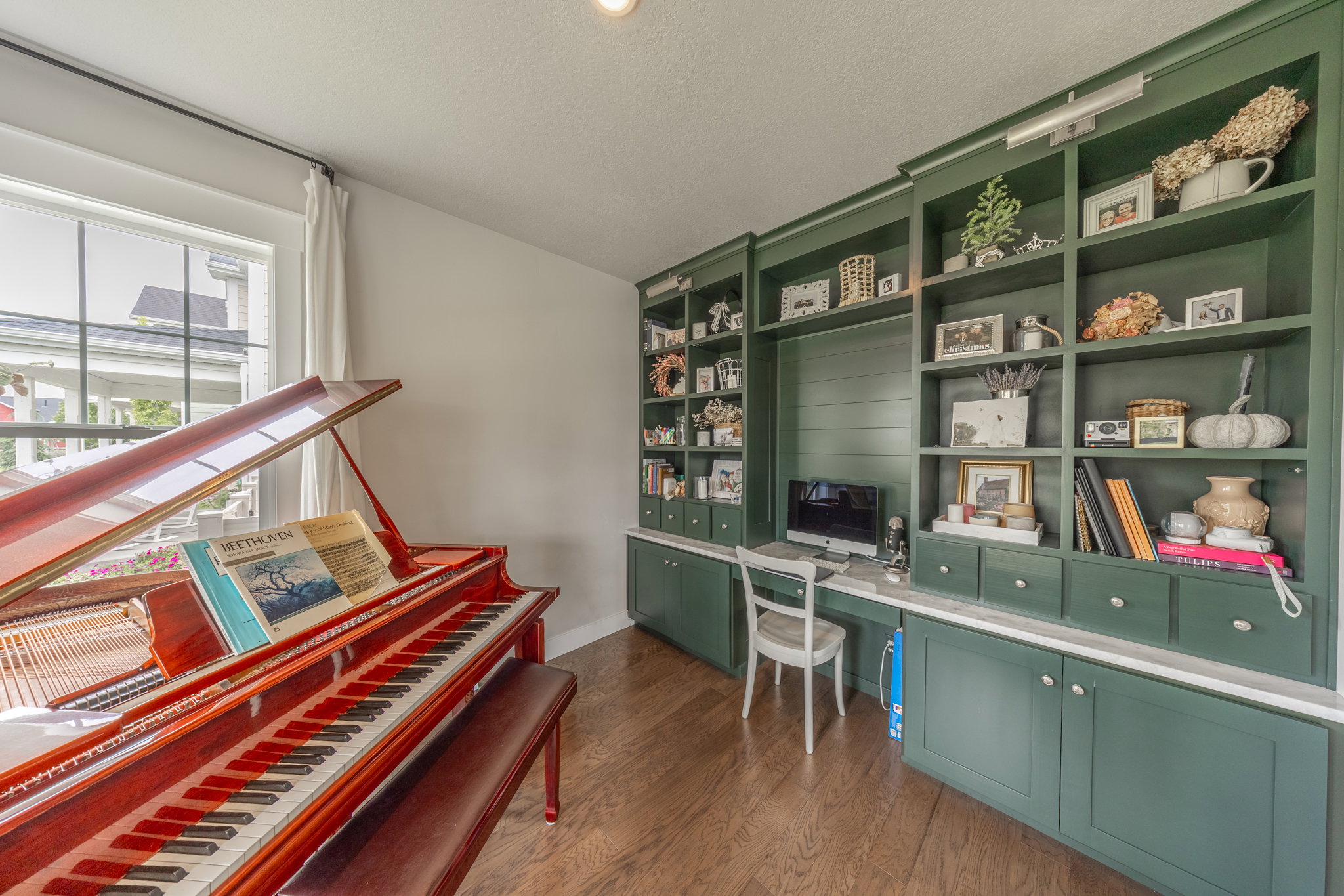 Built-in green cabinetry with shelving and desk space