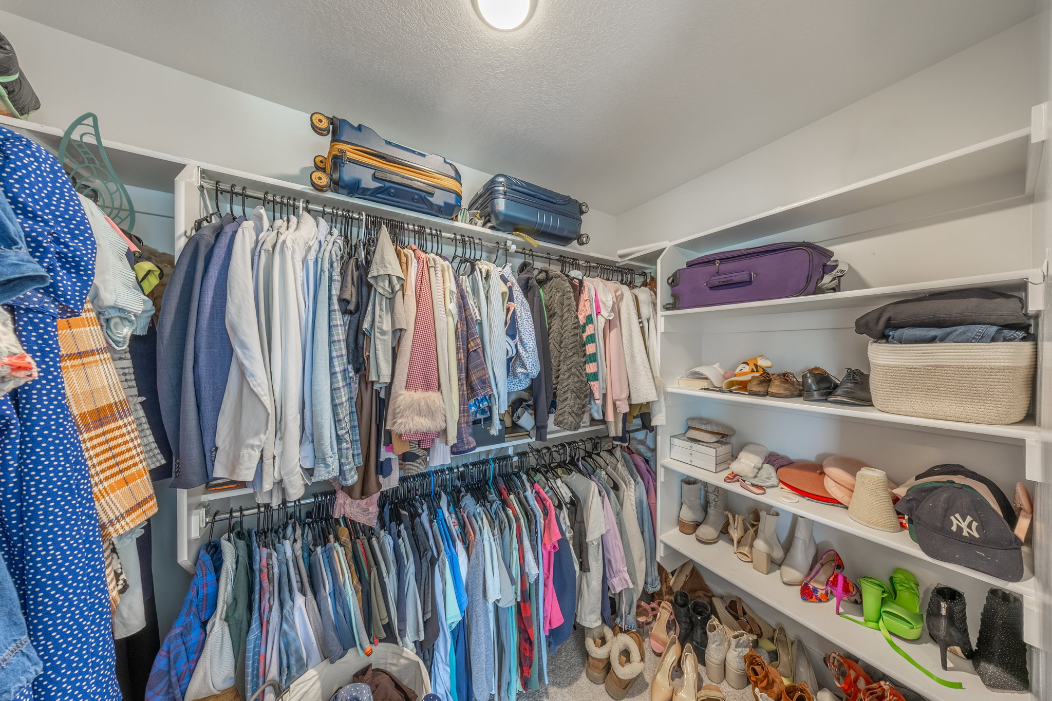 Walk-in closet featuring extensive built-in shelving, multiple hanging rods, and ample storage capacity