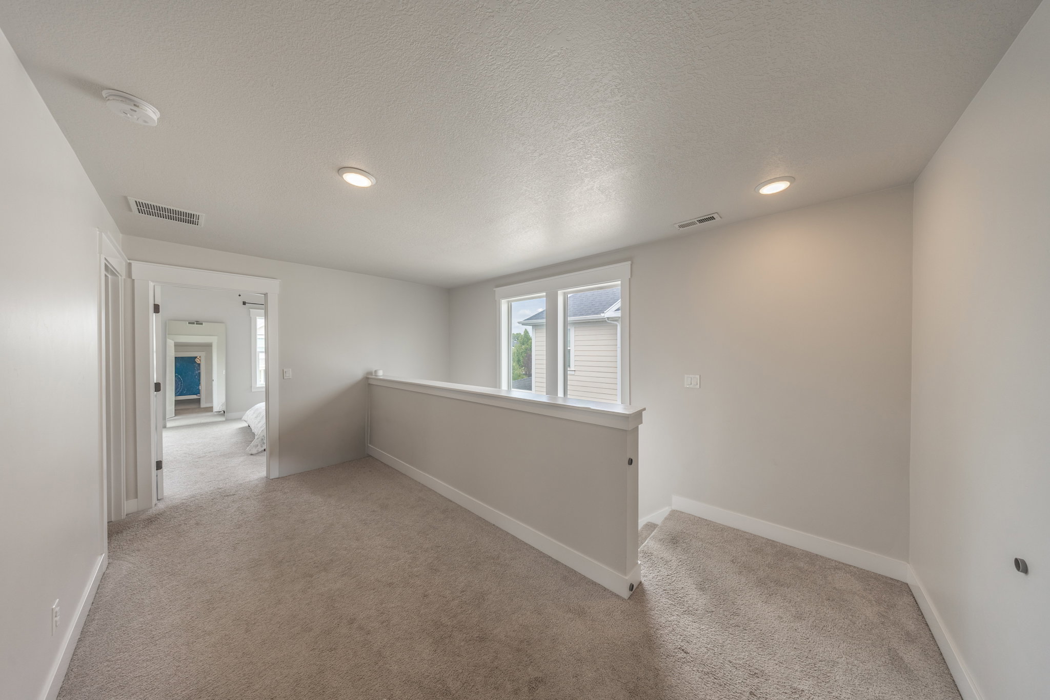 Carpeted landing area featuring recessed lighting, white trim, and a half-wall railing